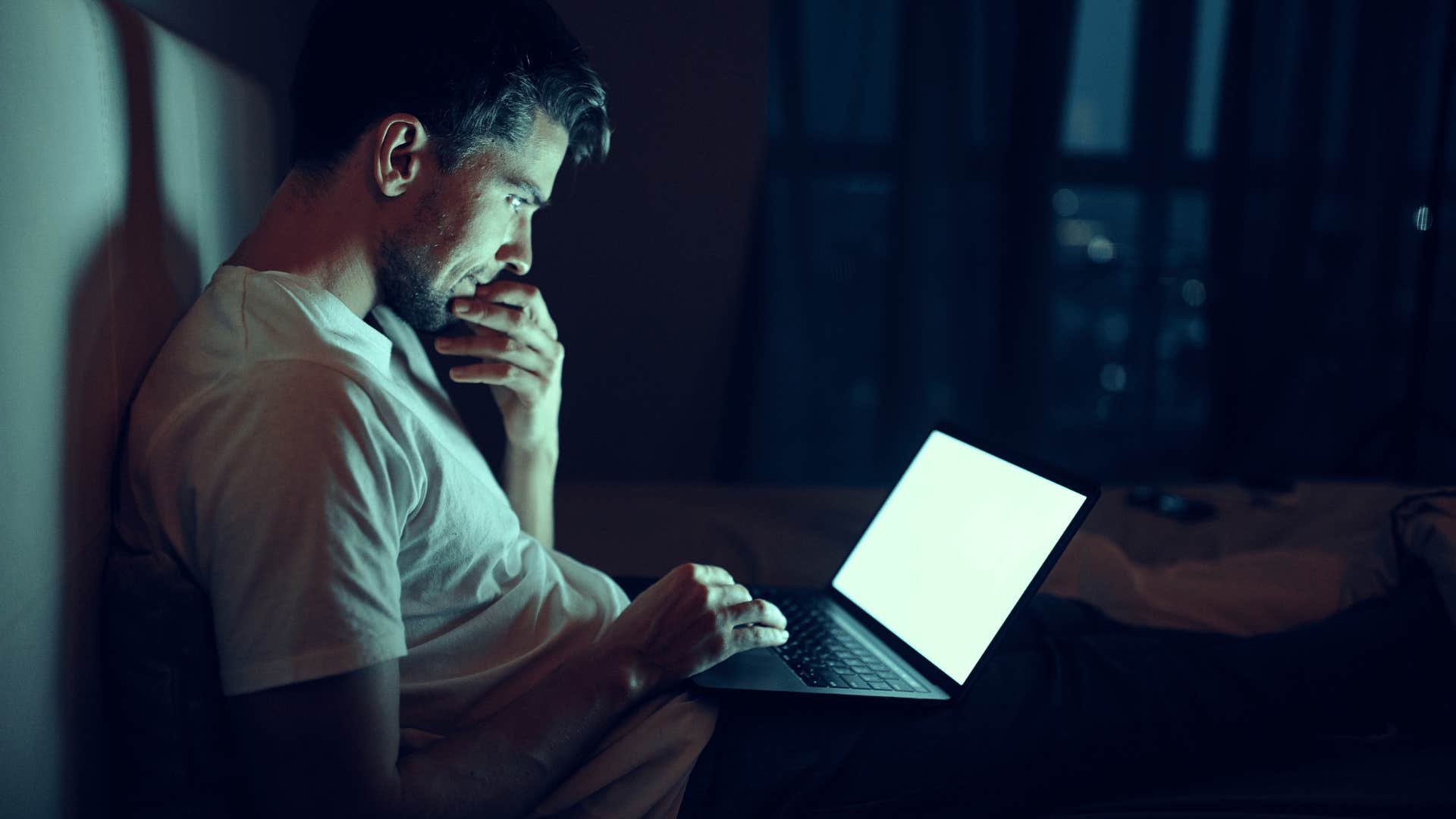 man on his computer in the dark