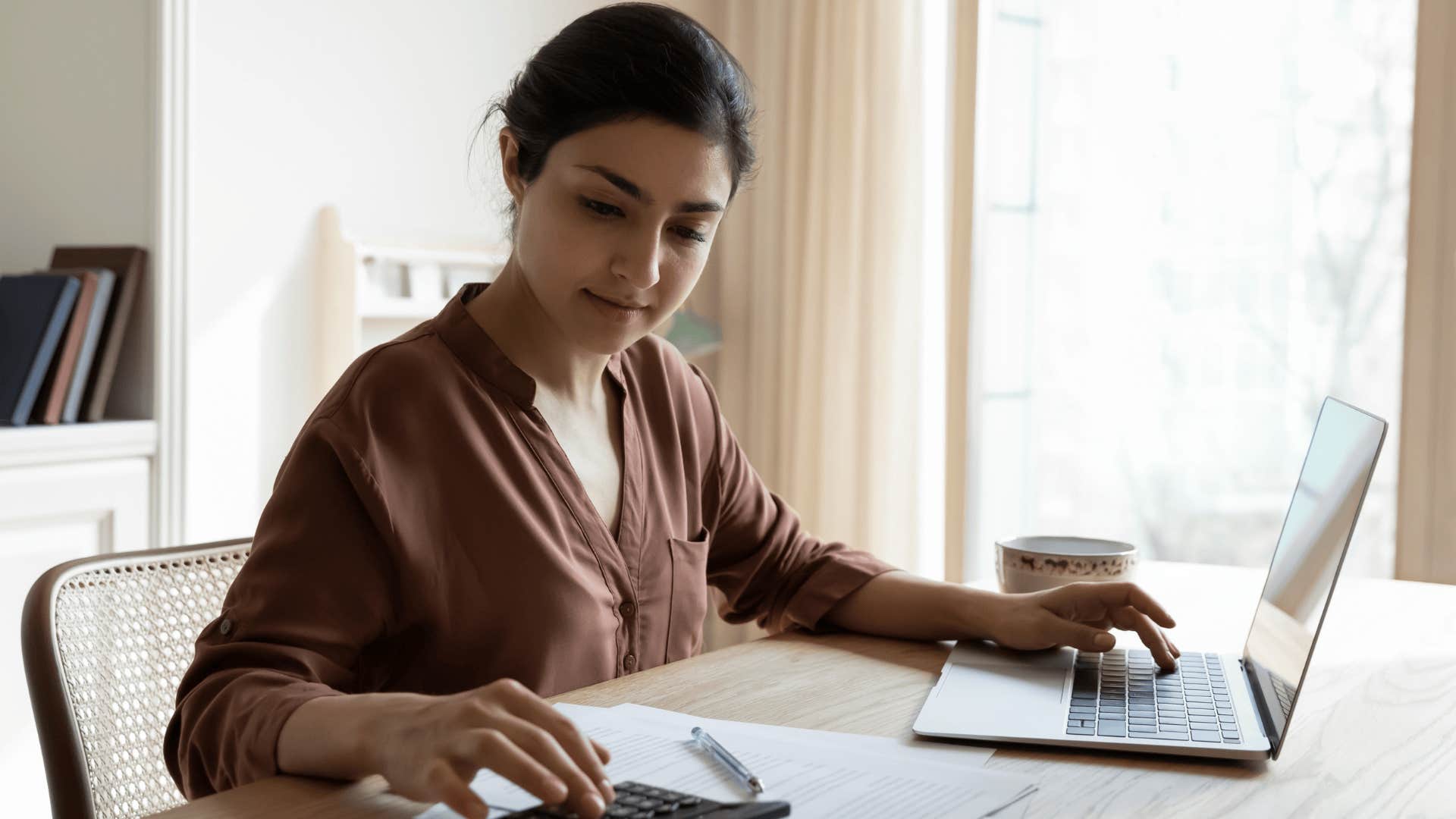 woman doing her bills at a table