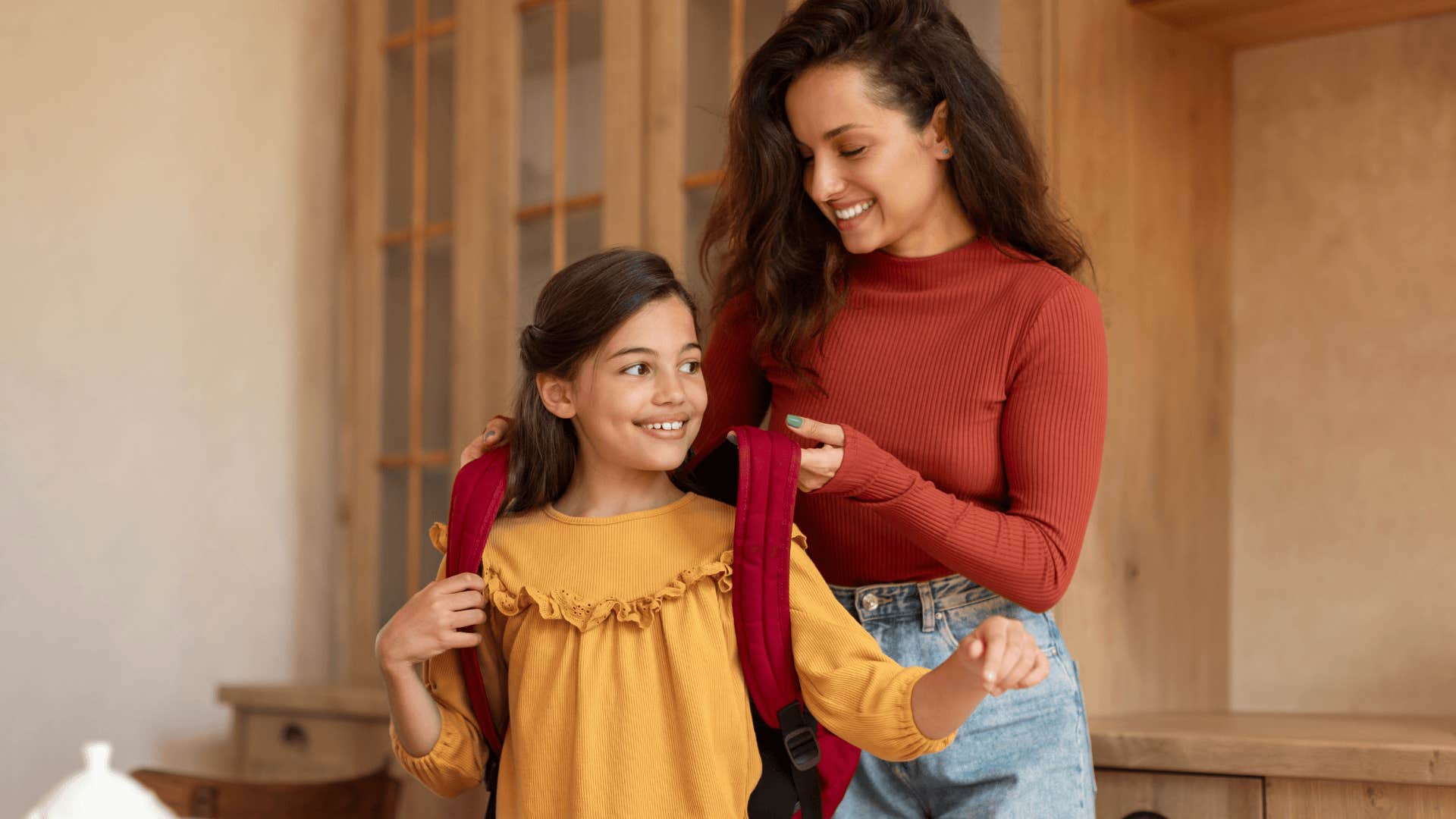 mom helping her daughter get ready for school