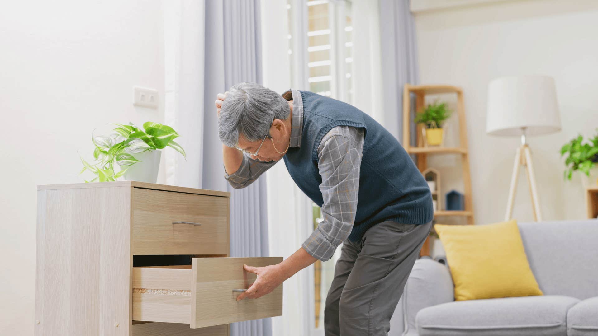 older man looking in drawer after losing his wallet