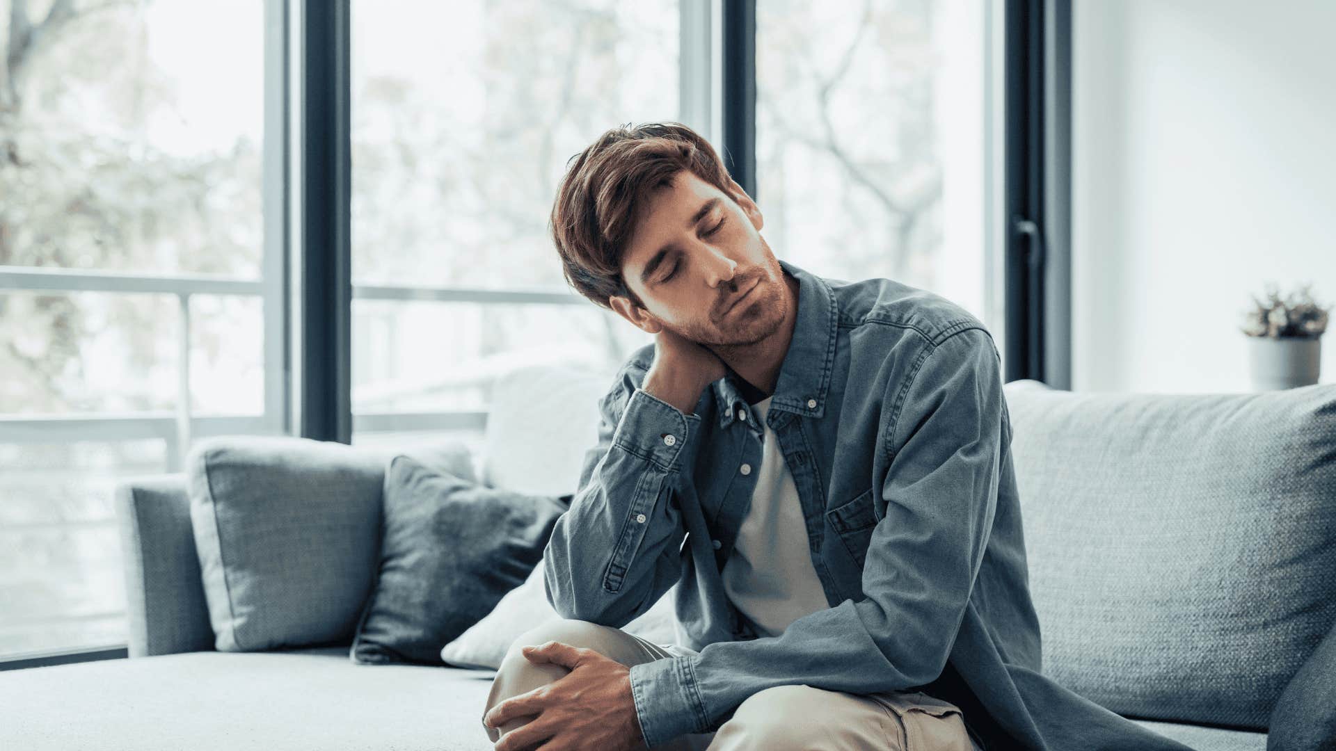 upset man sitting on couch after not getting something he worked for