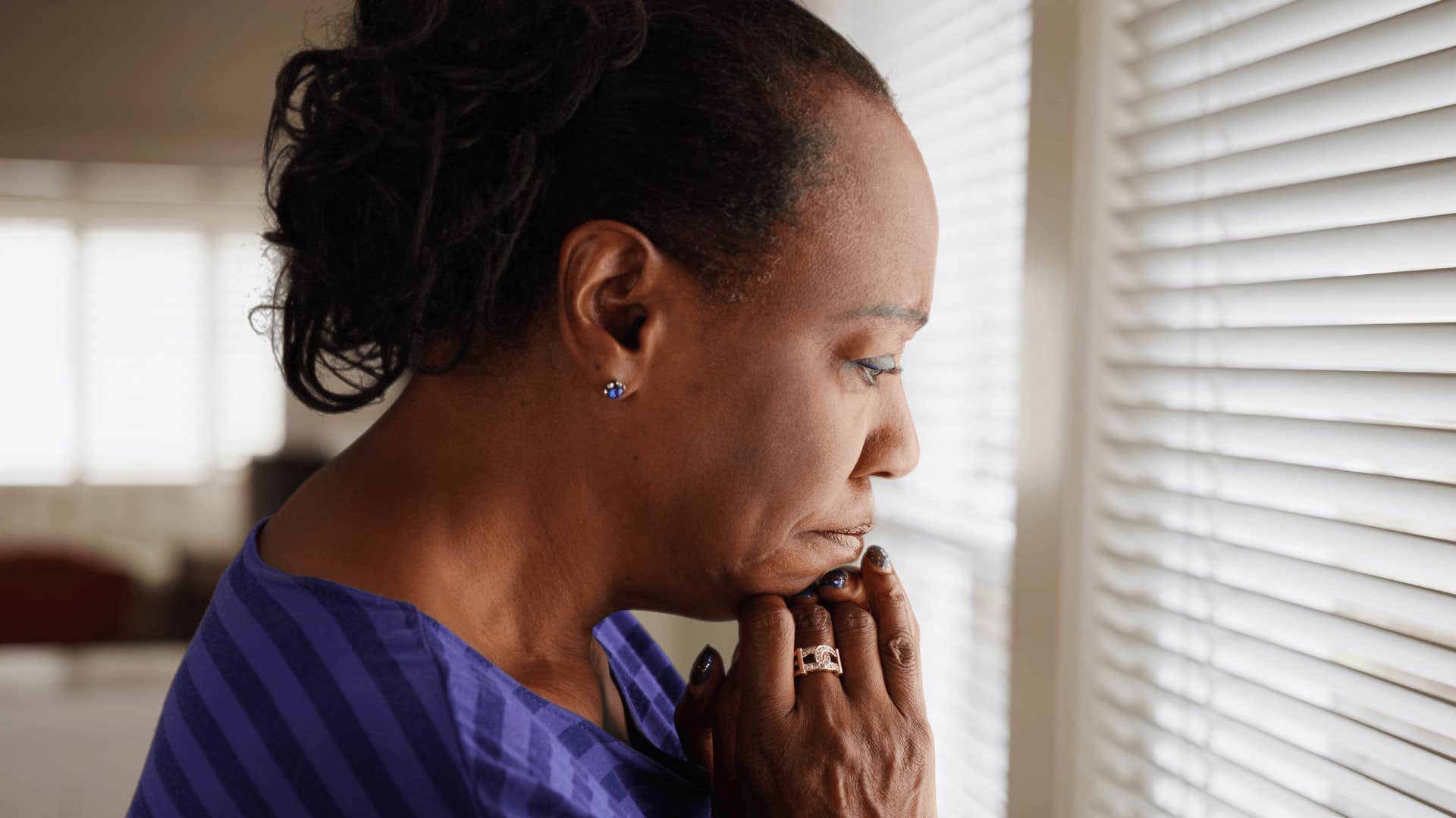 woman with persistent sadness looking out a window