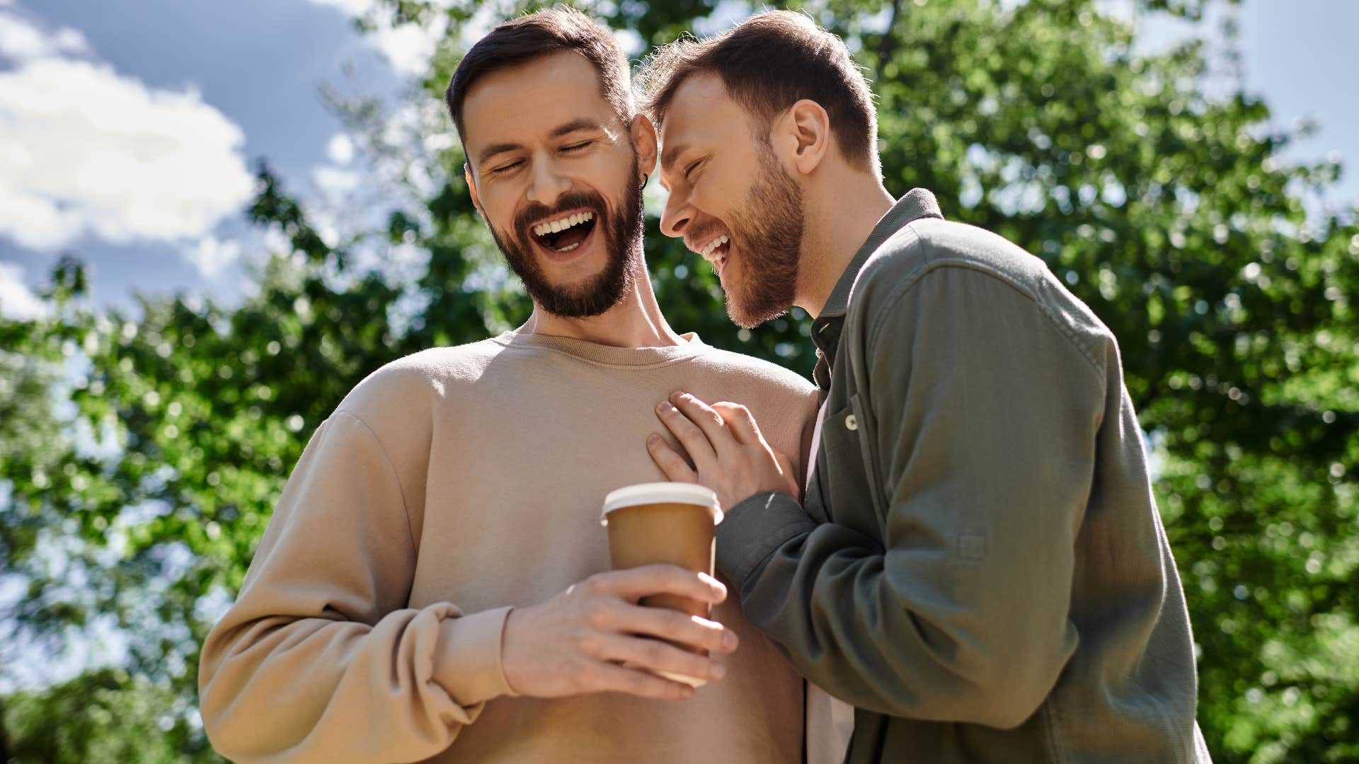 two men smiling and hugging outside