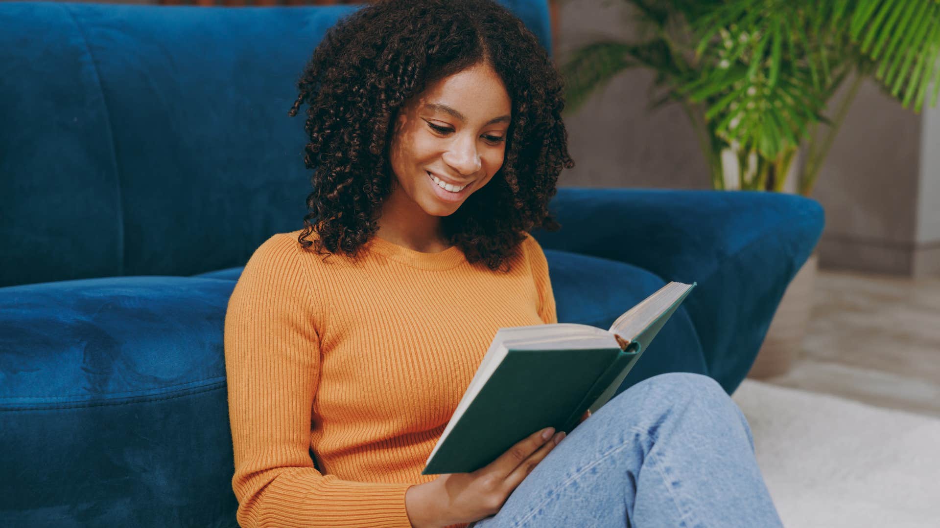young woman smiling and reading a book