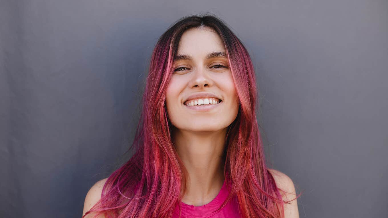 millennial woman with pink hair smiling