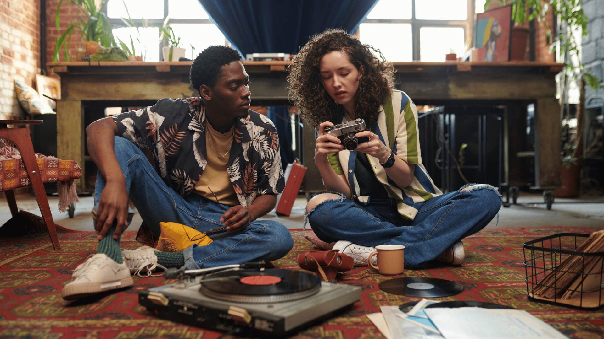 man and woman looking at retro camera and record player