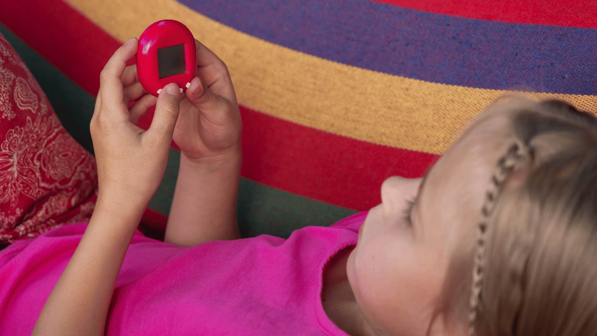 little girl playing with tamagotchi