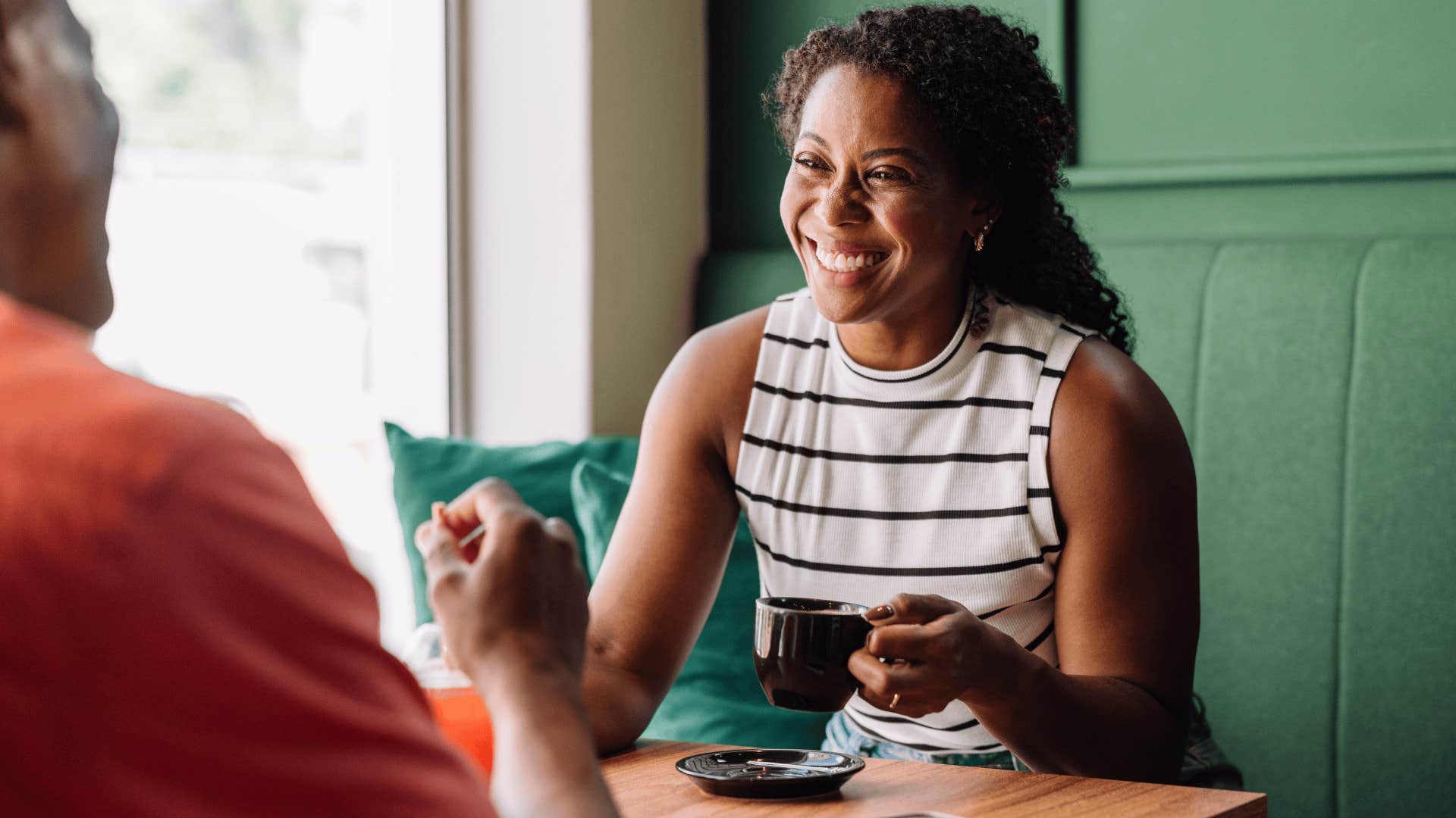 woman drinking coffee at a cafe with partner