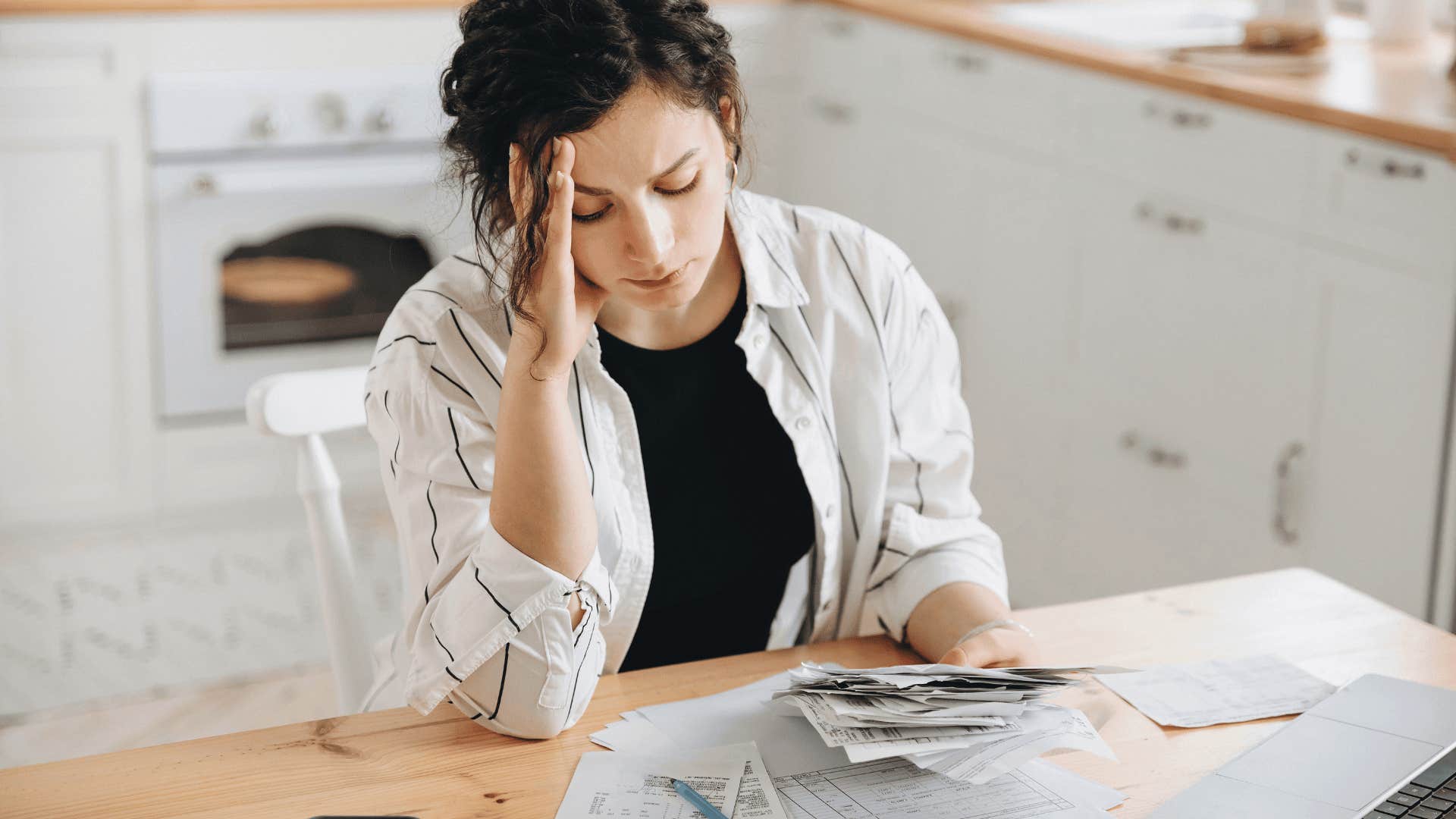 stressed woman looking at pile of bills