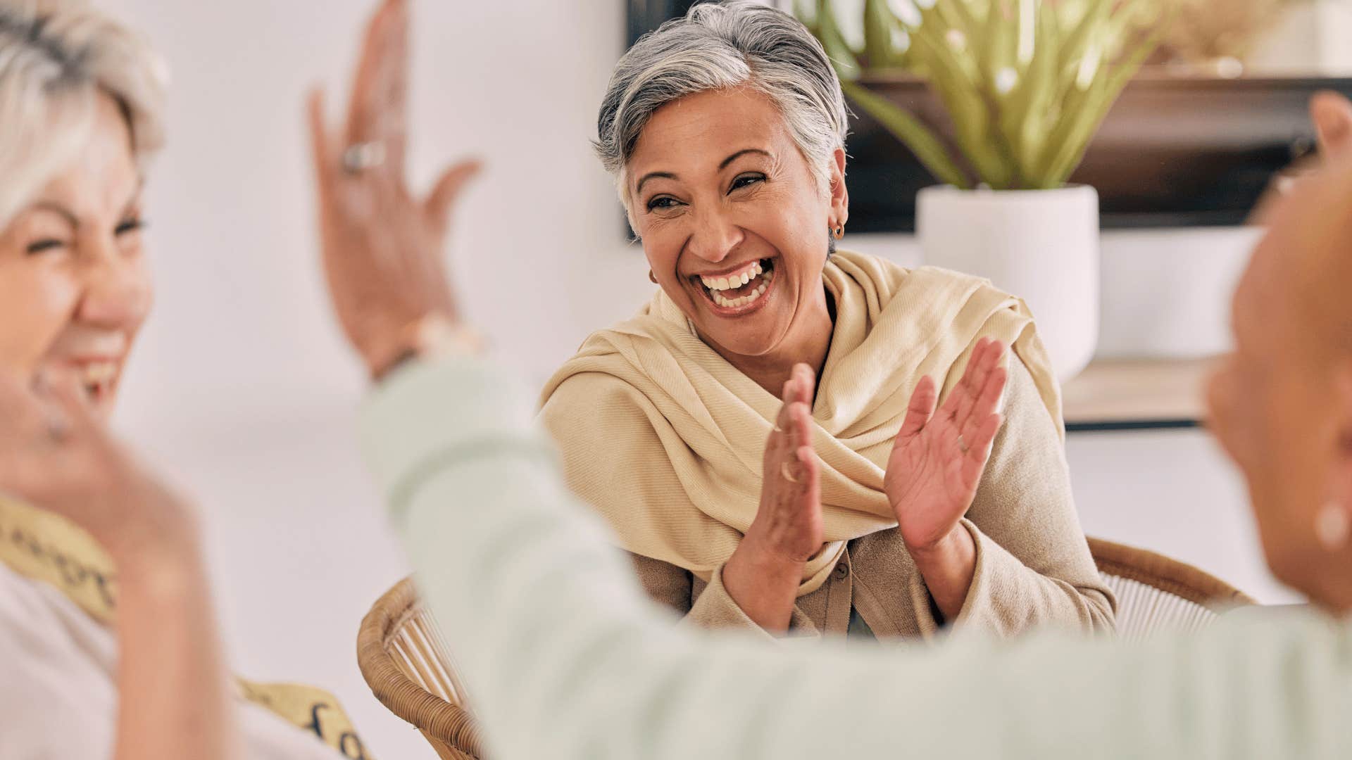 older woman smiling and talking with friends