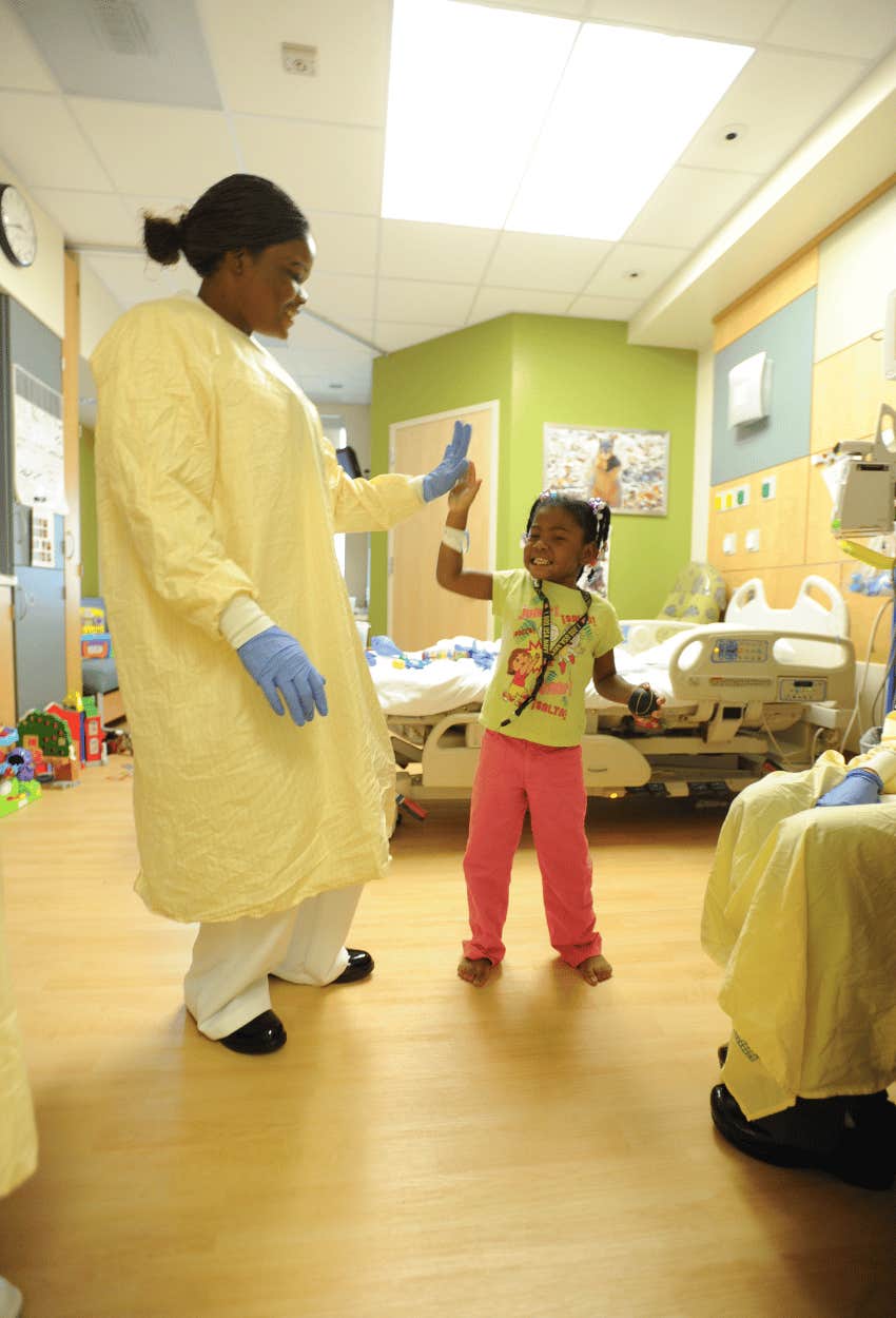 Nurse celebrating after a little girl with measles gets better