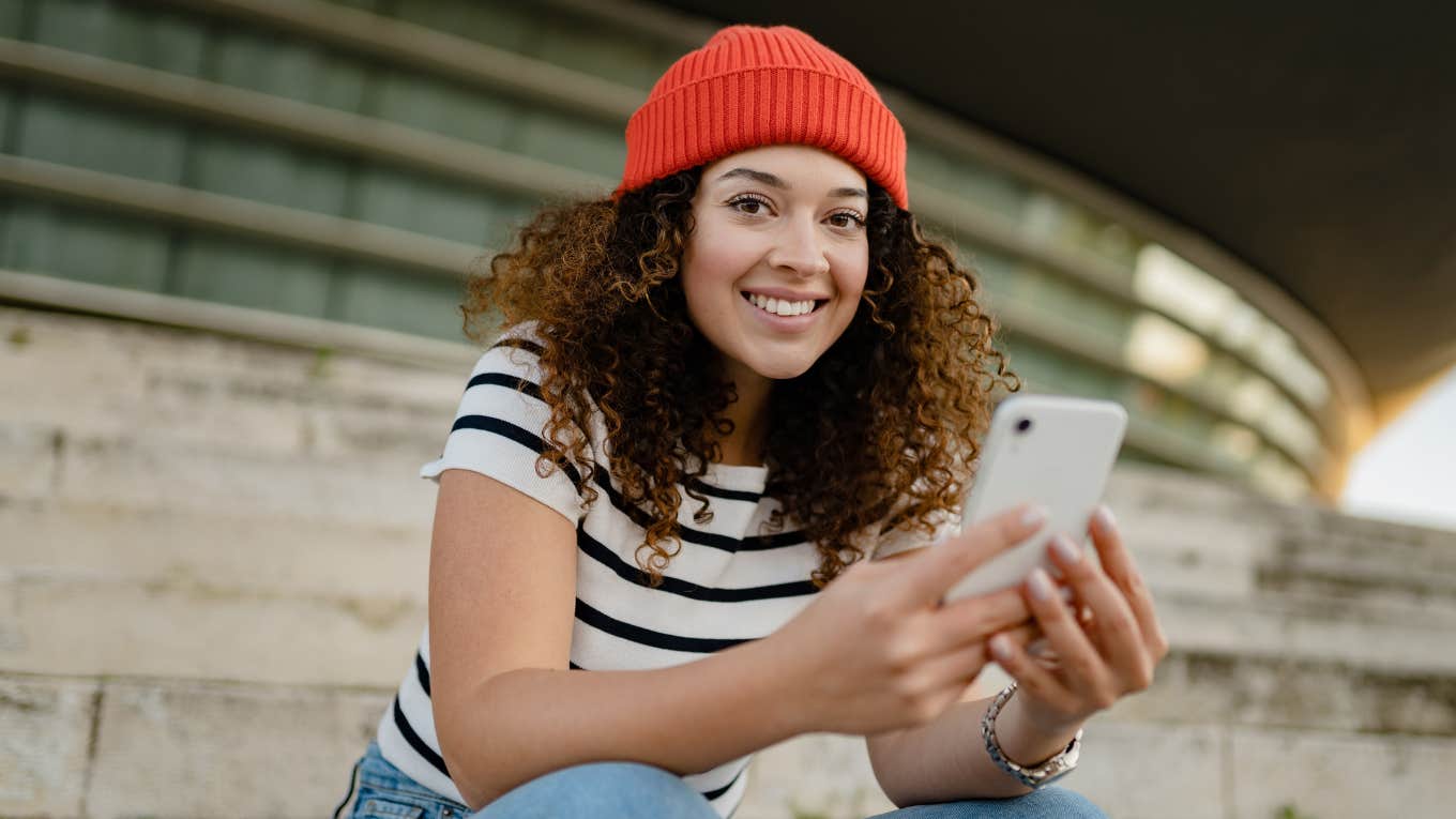 Values Millennials Think Are Important But Mean Very Little To Older Generations millennial woman sitting on stairs on her phone