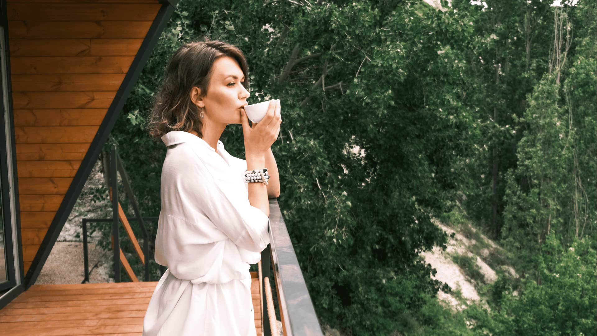 woman drinking coffee on porch