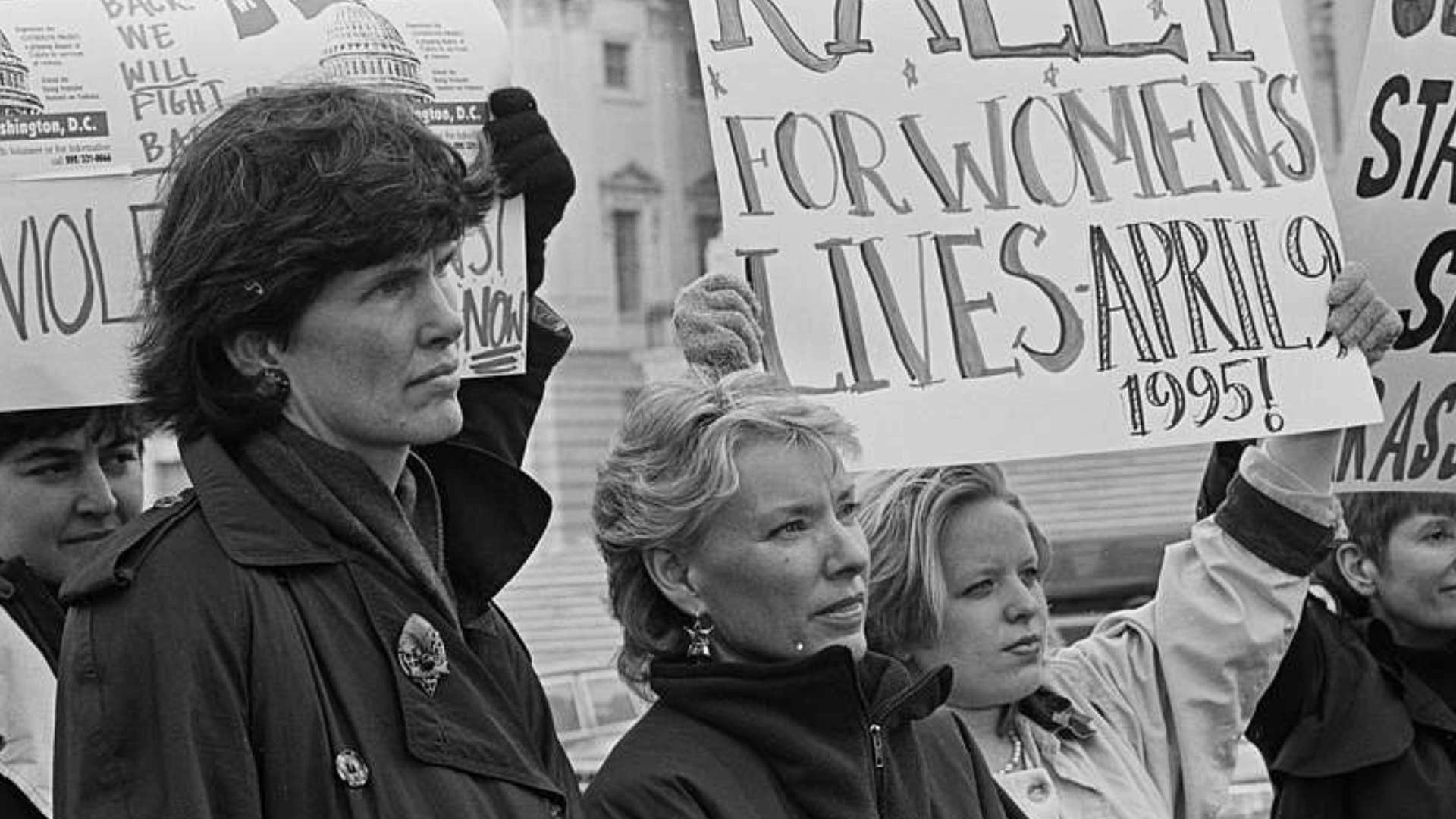 boomer women outside the U.S. Capitol holding signs for women's rights