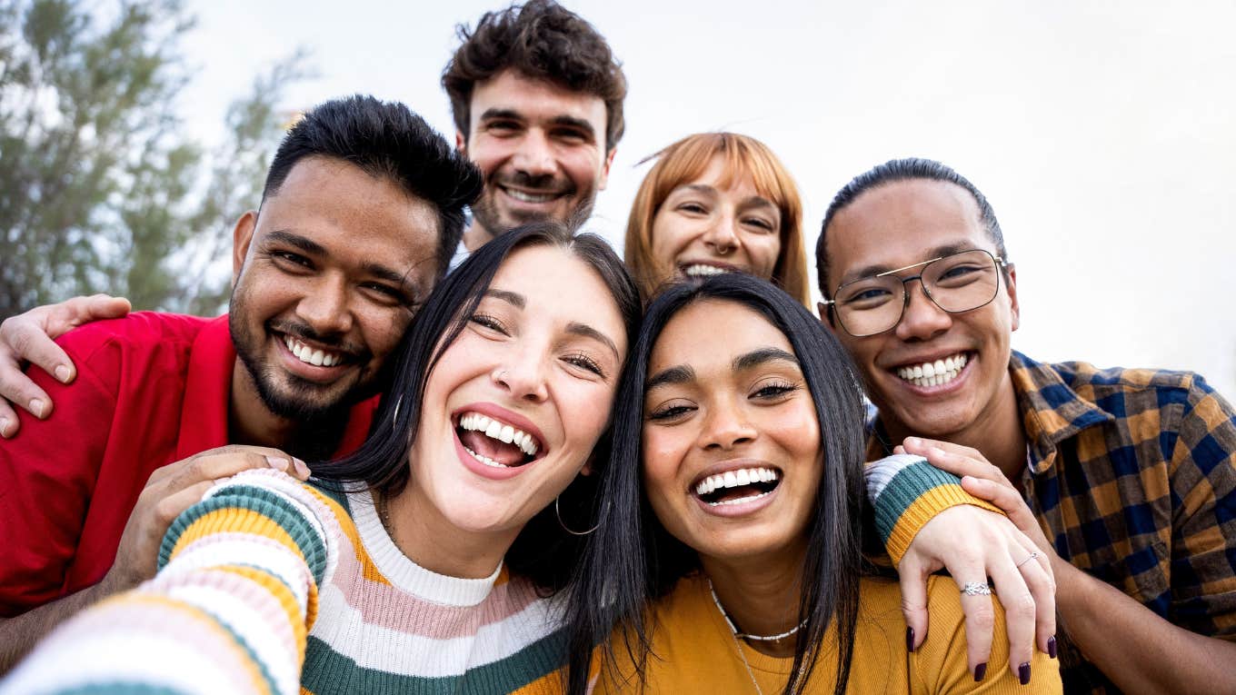 Ways Gen Z Builds Community Outside Their Phones That Older Generations Could Really Learn From group of Gen Z friends smiling