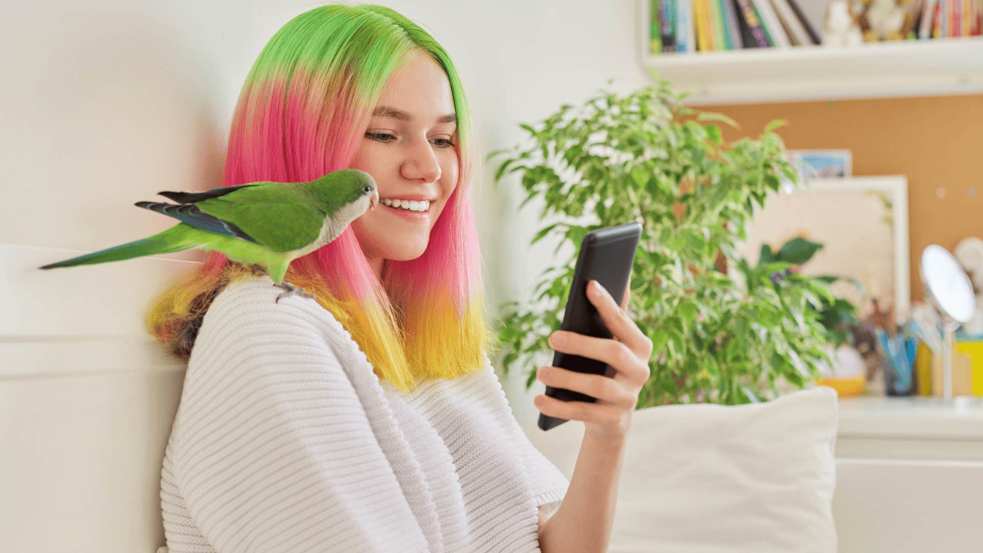 Gen Z woman looking at her phone with a pet bird with a nontraditional name