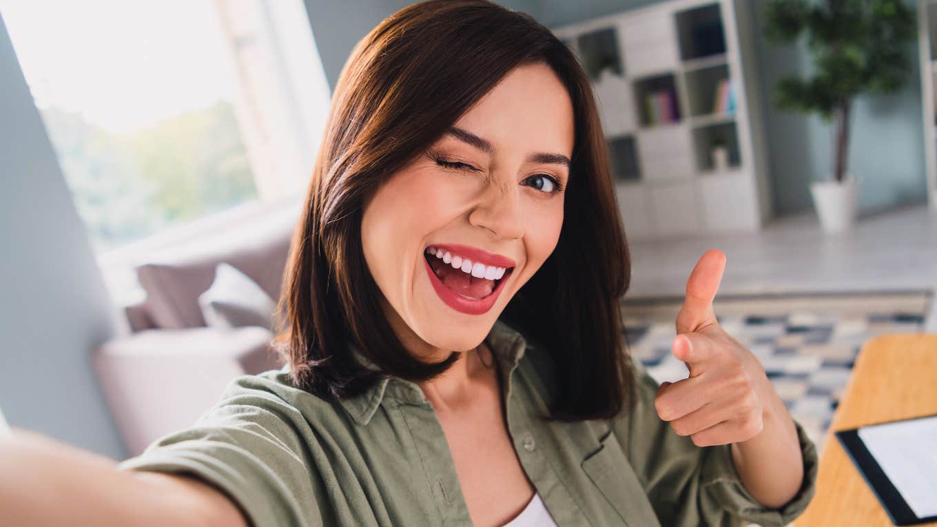 woman winking at work as she secretly makes her job easier without her boss noticing