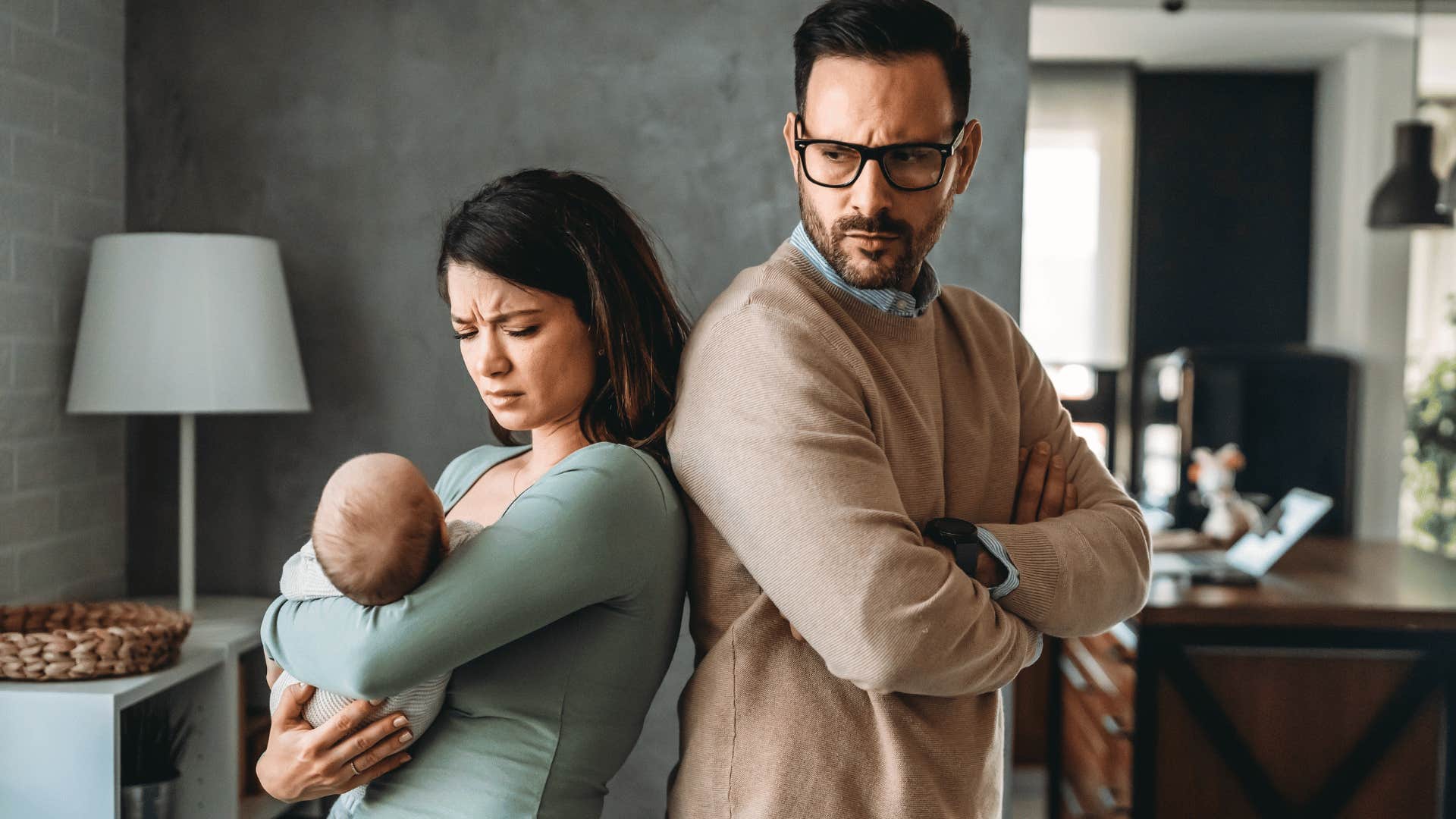 stressed sad man turned away from wife and baby