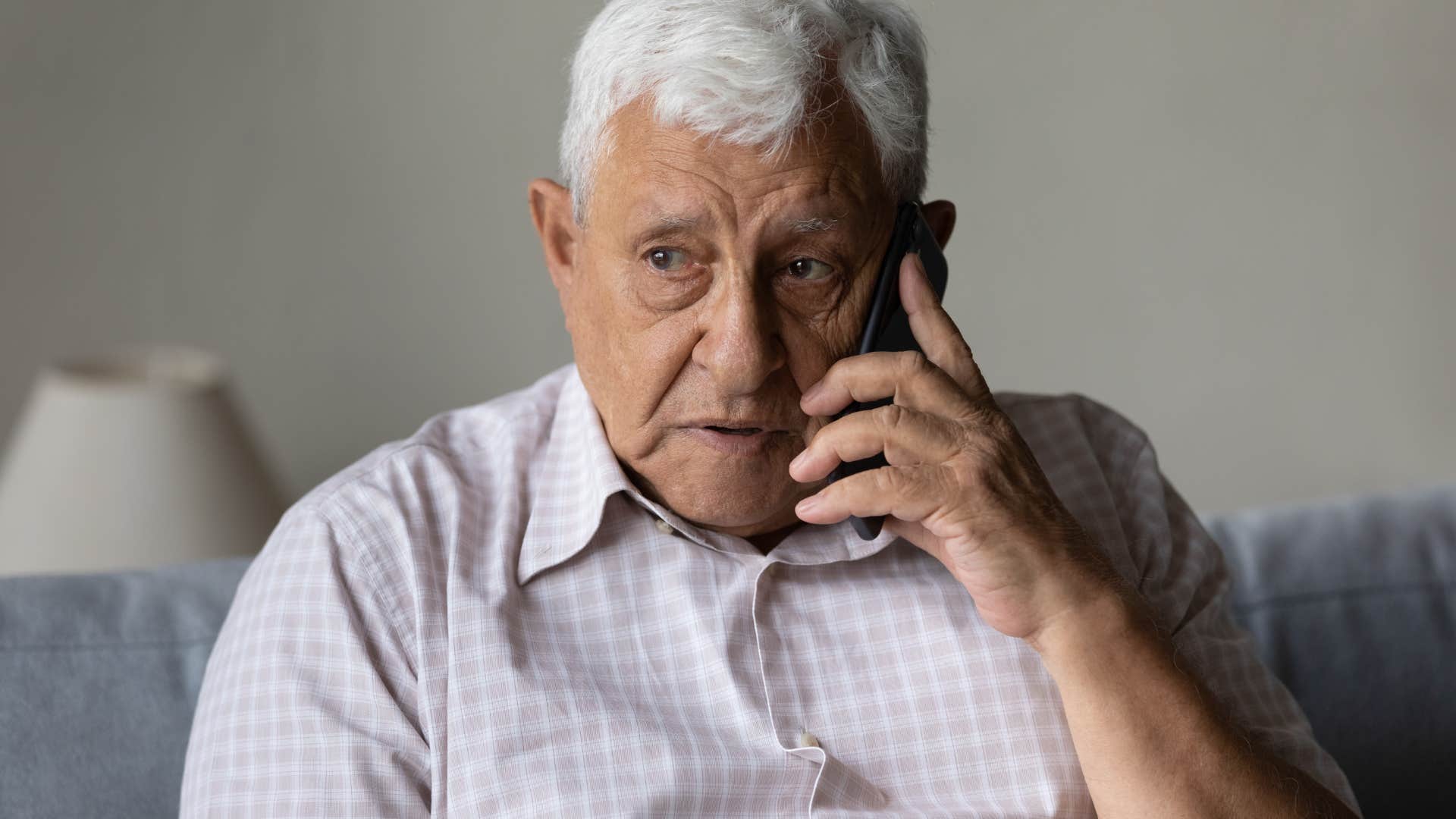 older insecure father talking to adult child on the phone