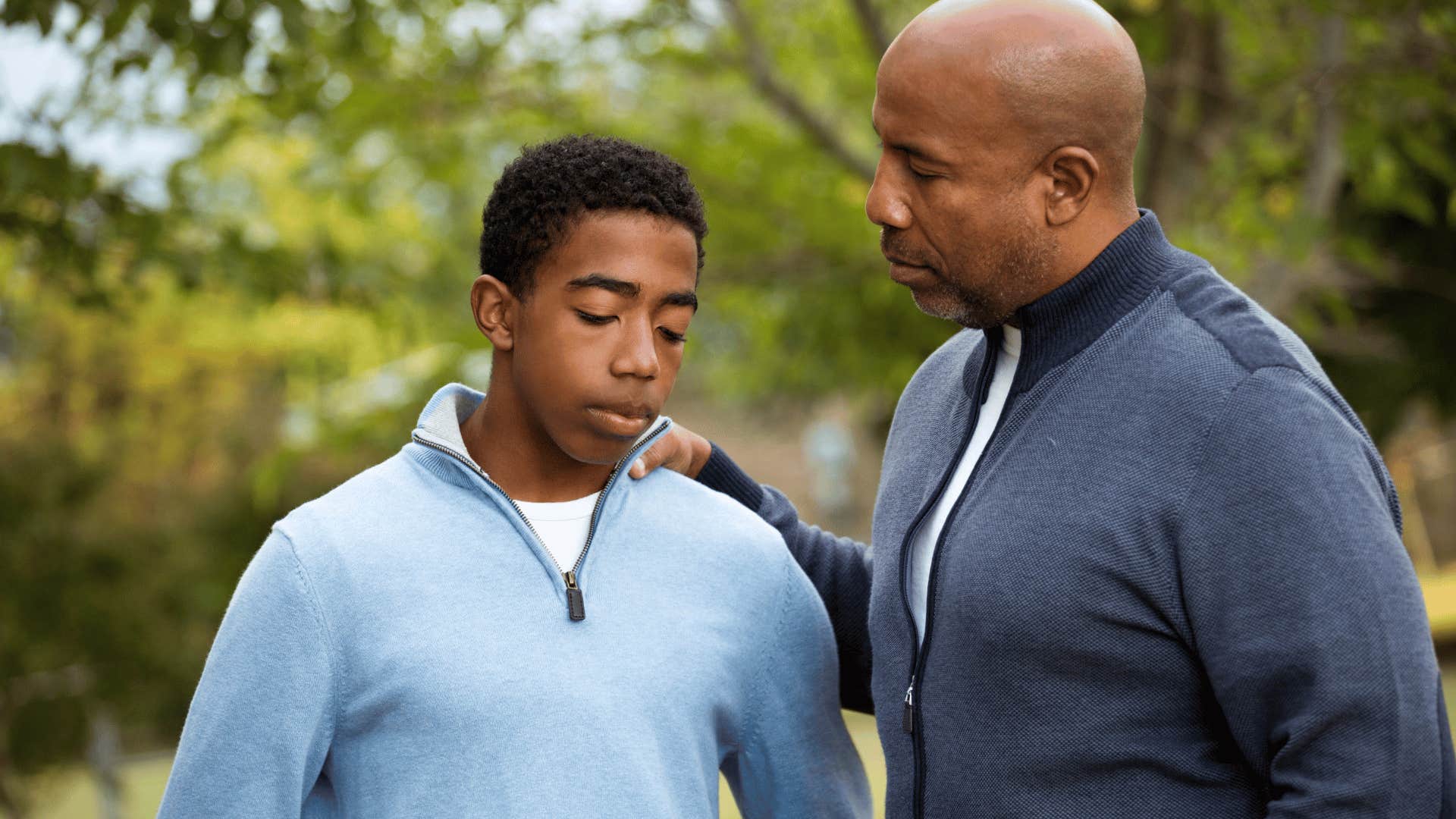 Upset adult son whose boundaries aren't respected at home standing next to his dad.