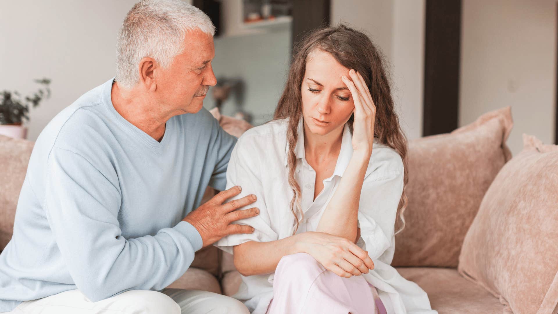 Overly dependent parent comforting his upset adult daughter.