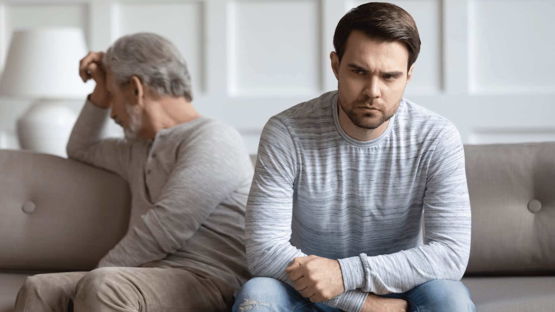 Man who's still treated like a child by his family sitting next to his upset father.