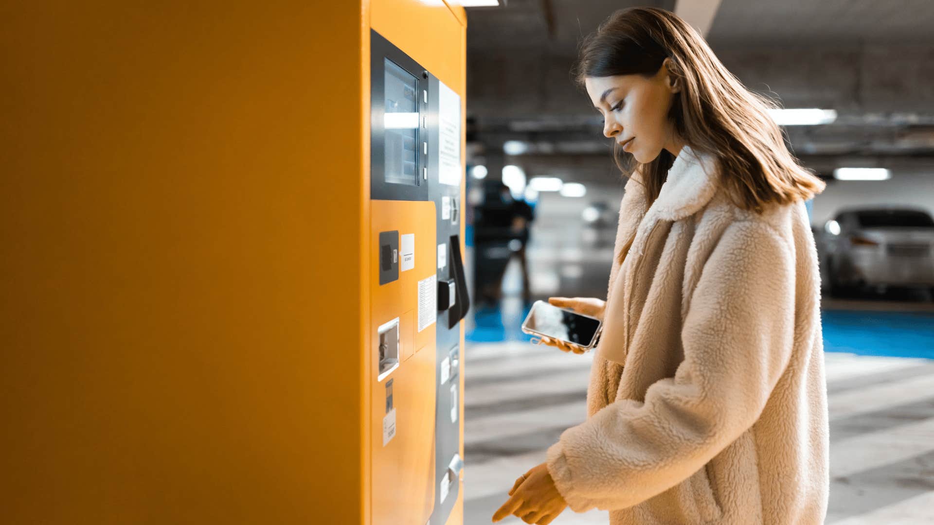 annoyed woman paying for parking her car in a lot