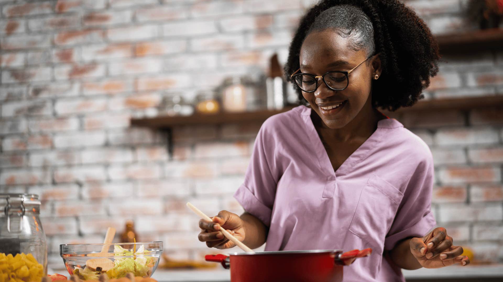 young woman smiling cooking in her kitchen