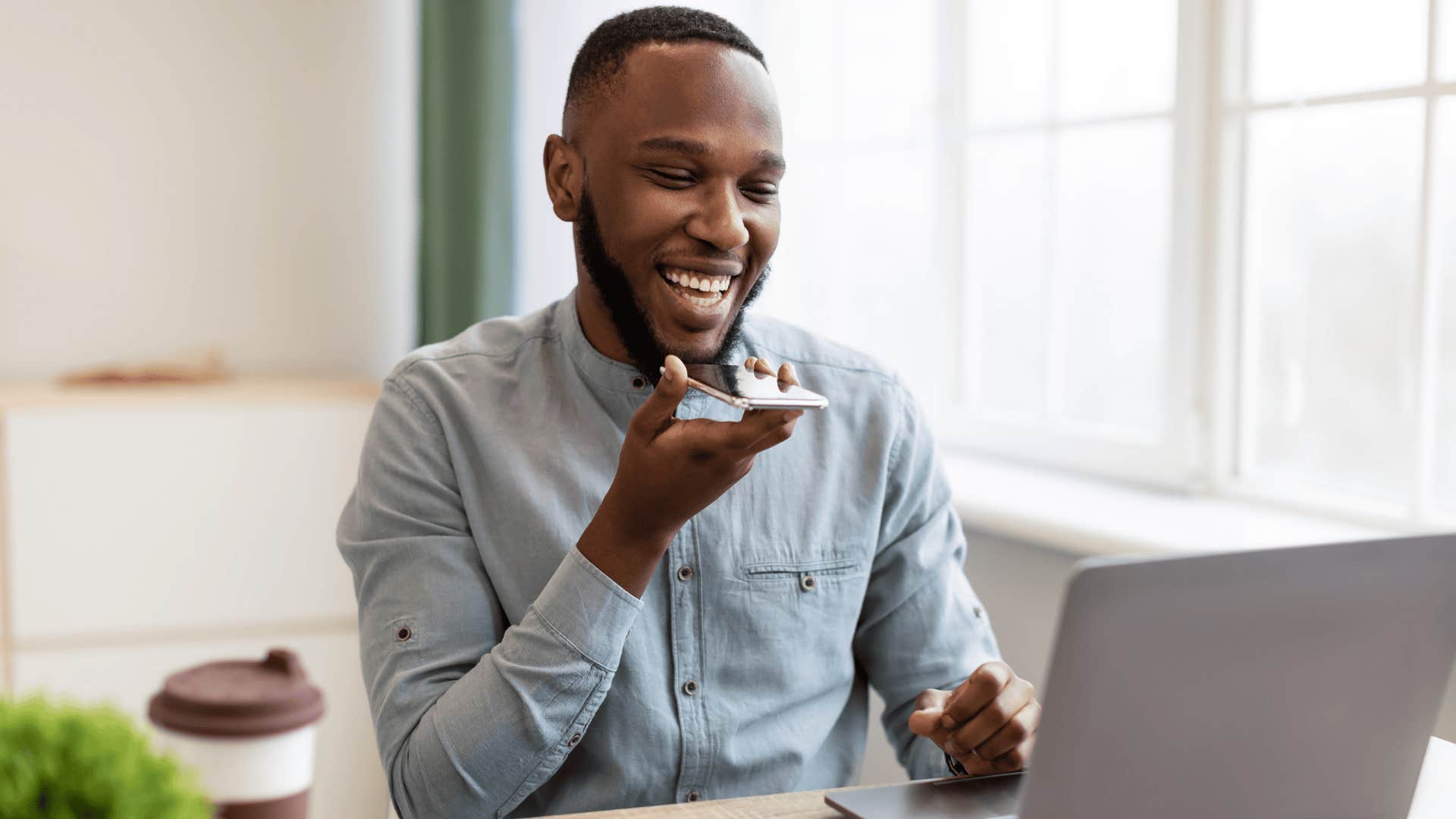 young man smiling while talking on the phone