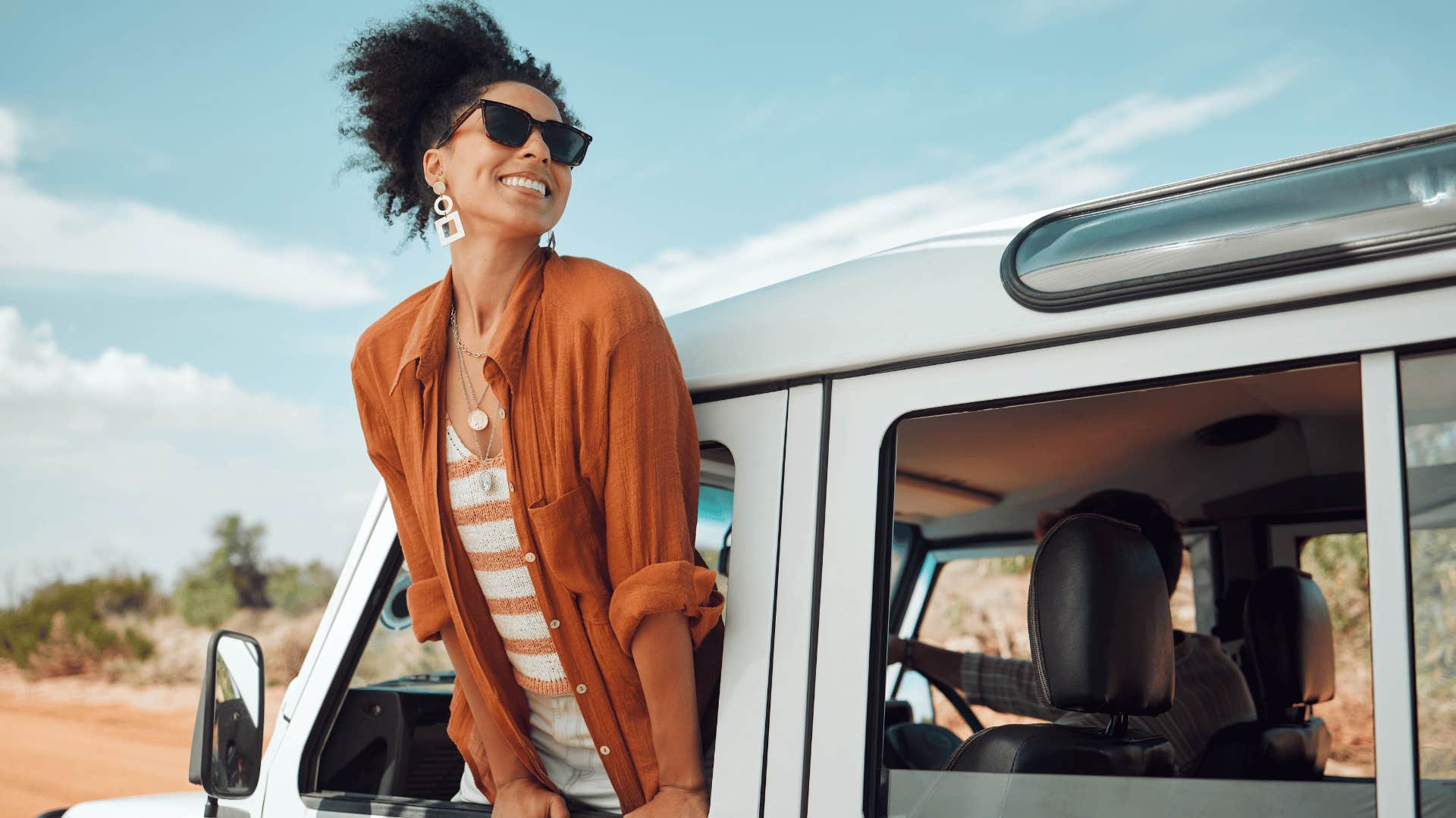 woman with sunglasses being authentic to herself as she travels and looks out the window