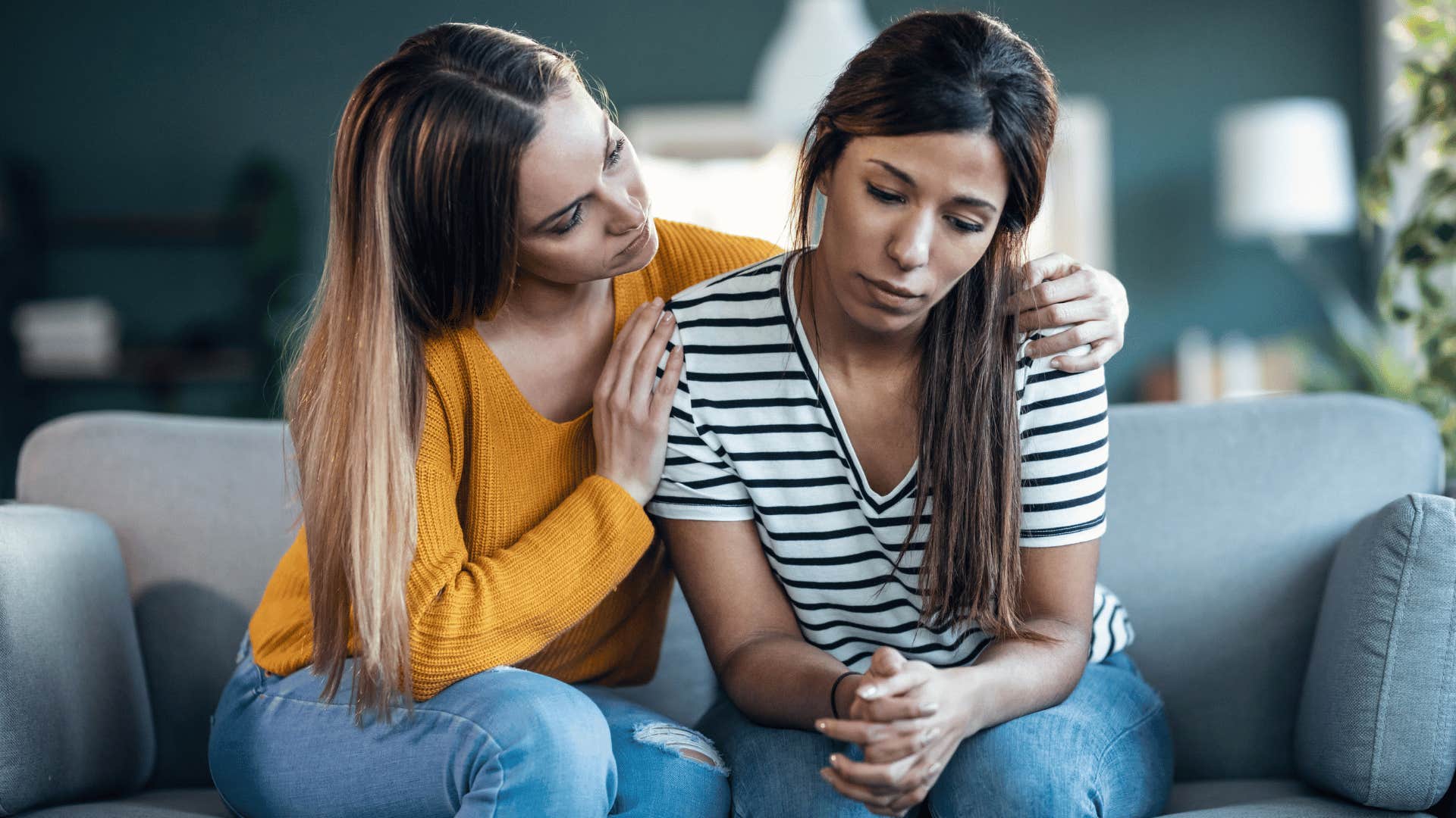 woman with yellow shirt having empathy for others as she comforts friend
