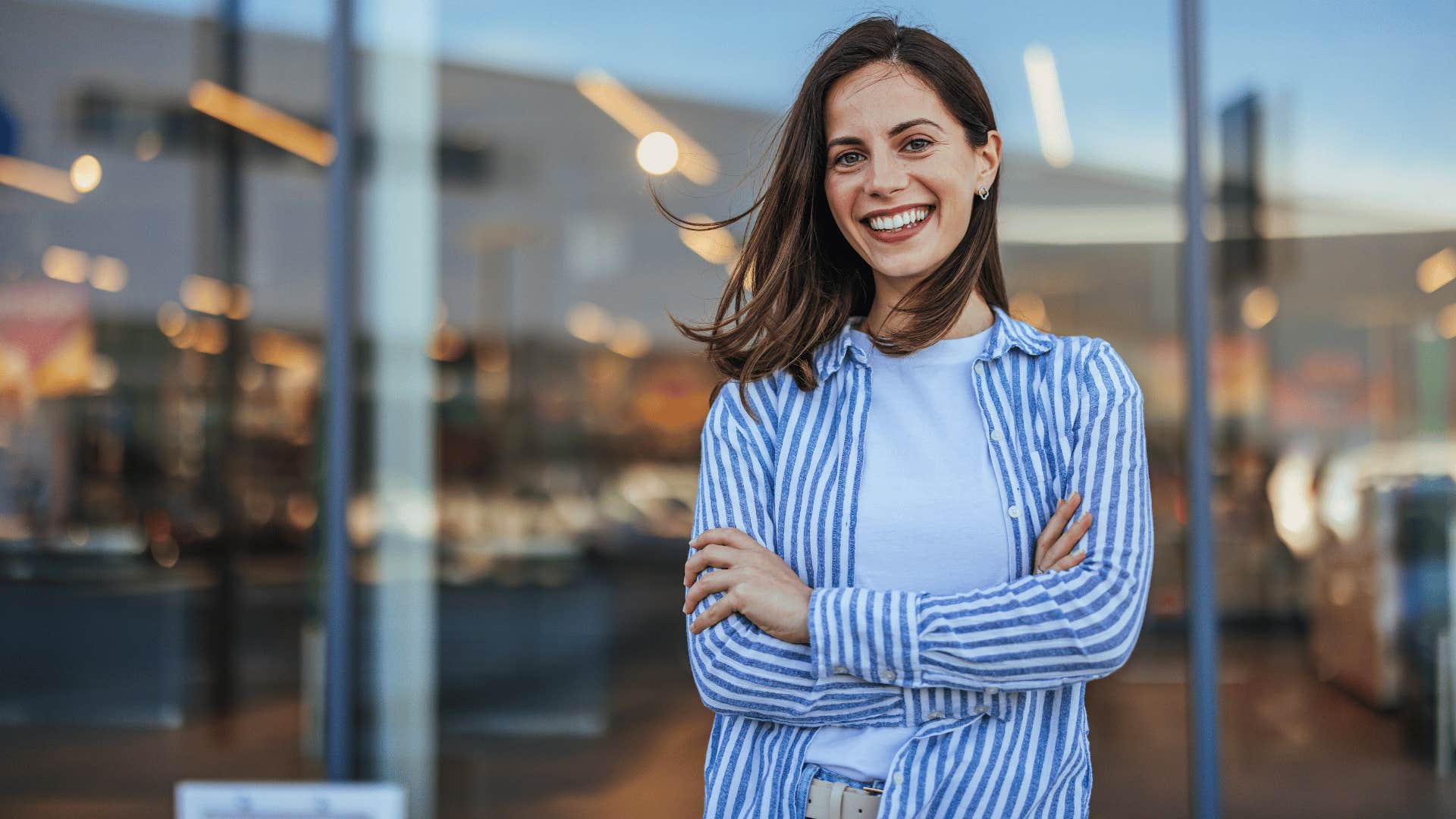 woman being realistically optimistic as she crosses her arms and smiles at the camera