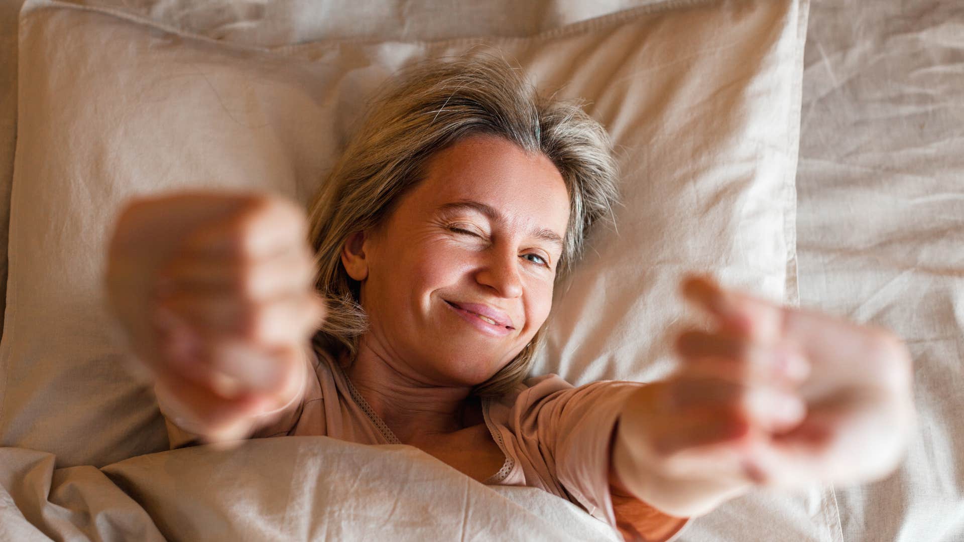 woman with winner mindset waking up smiling to start morning routine