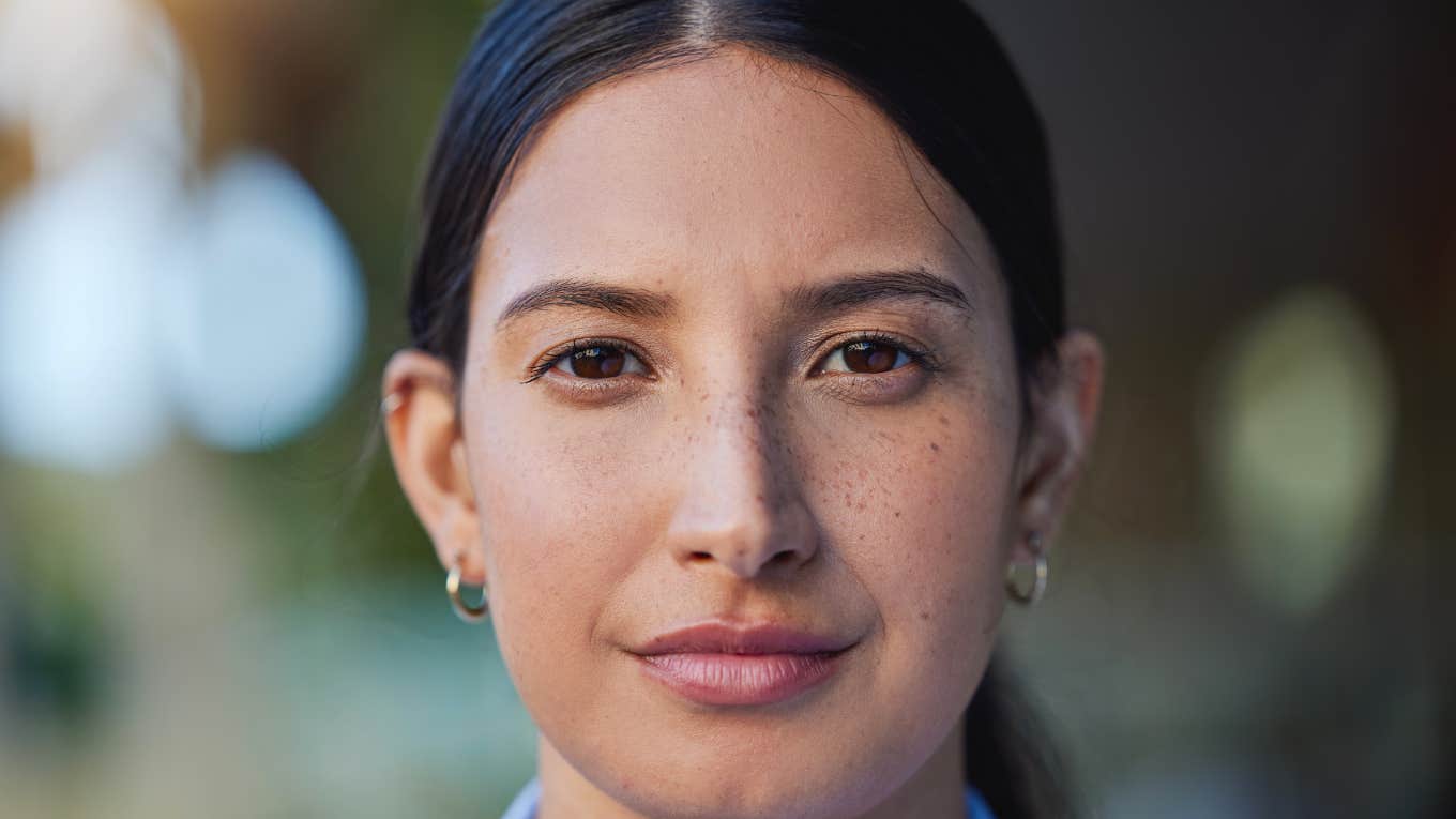 evil woman with kind eyes smiling slightly