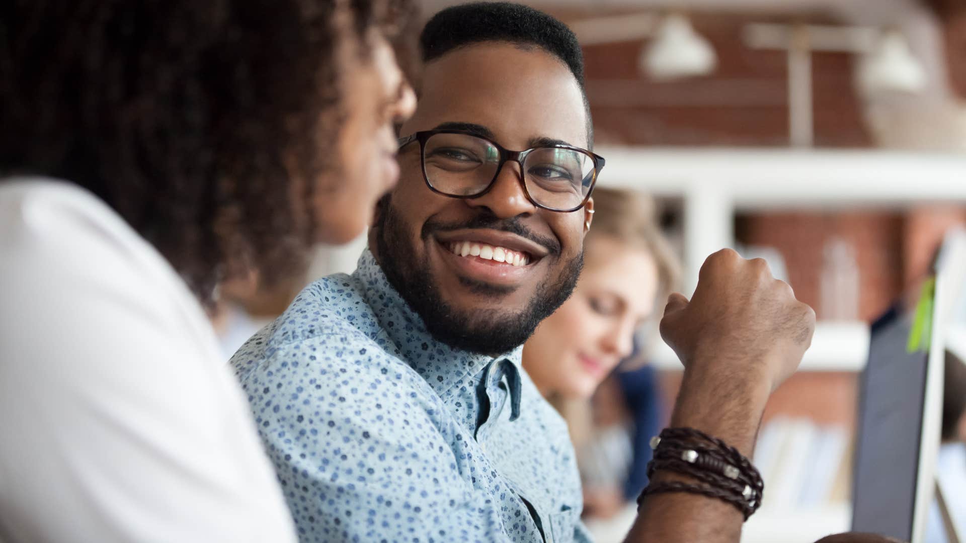 charismatic man smiling around co-worker and friend