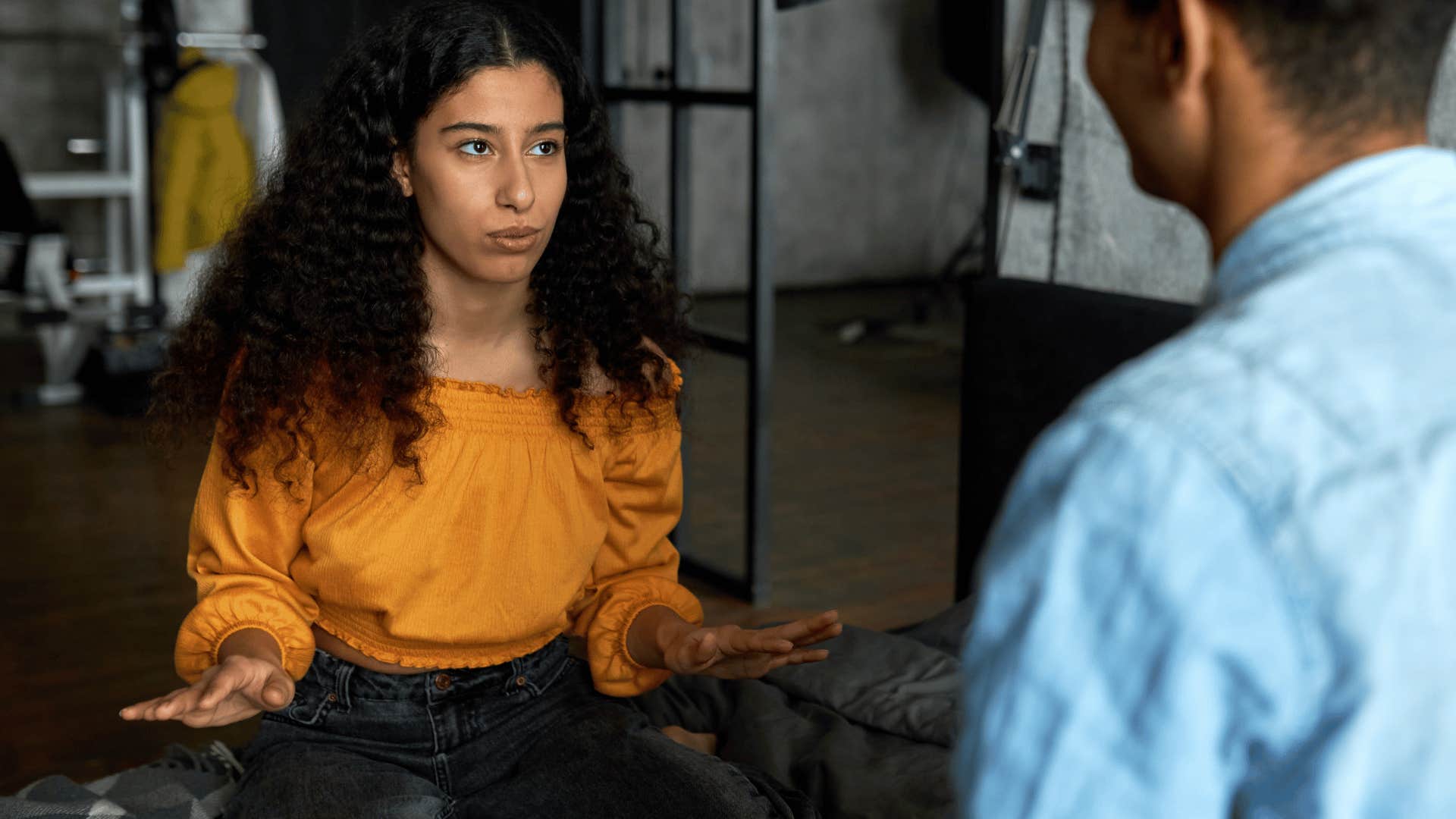 woman in orange shirt doing her best to be honest and respectful with man in blue shirt