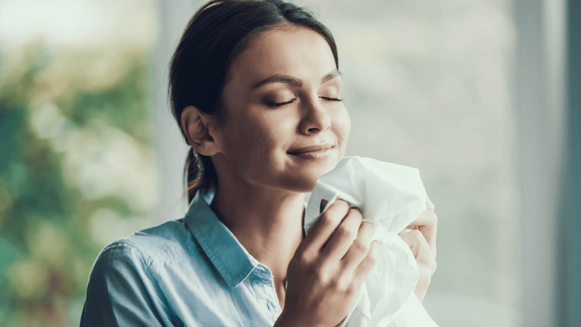 content woman smelling fresh laundry