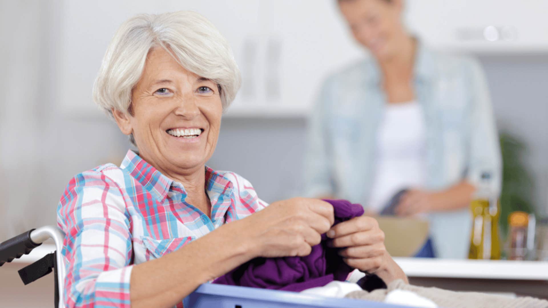 smiling older woman folding laundry