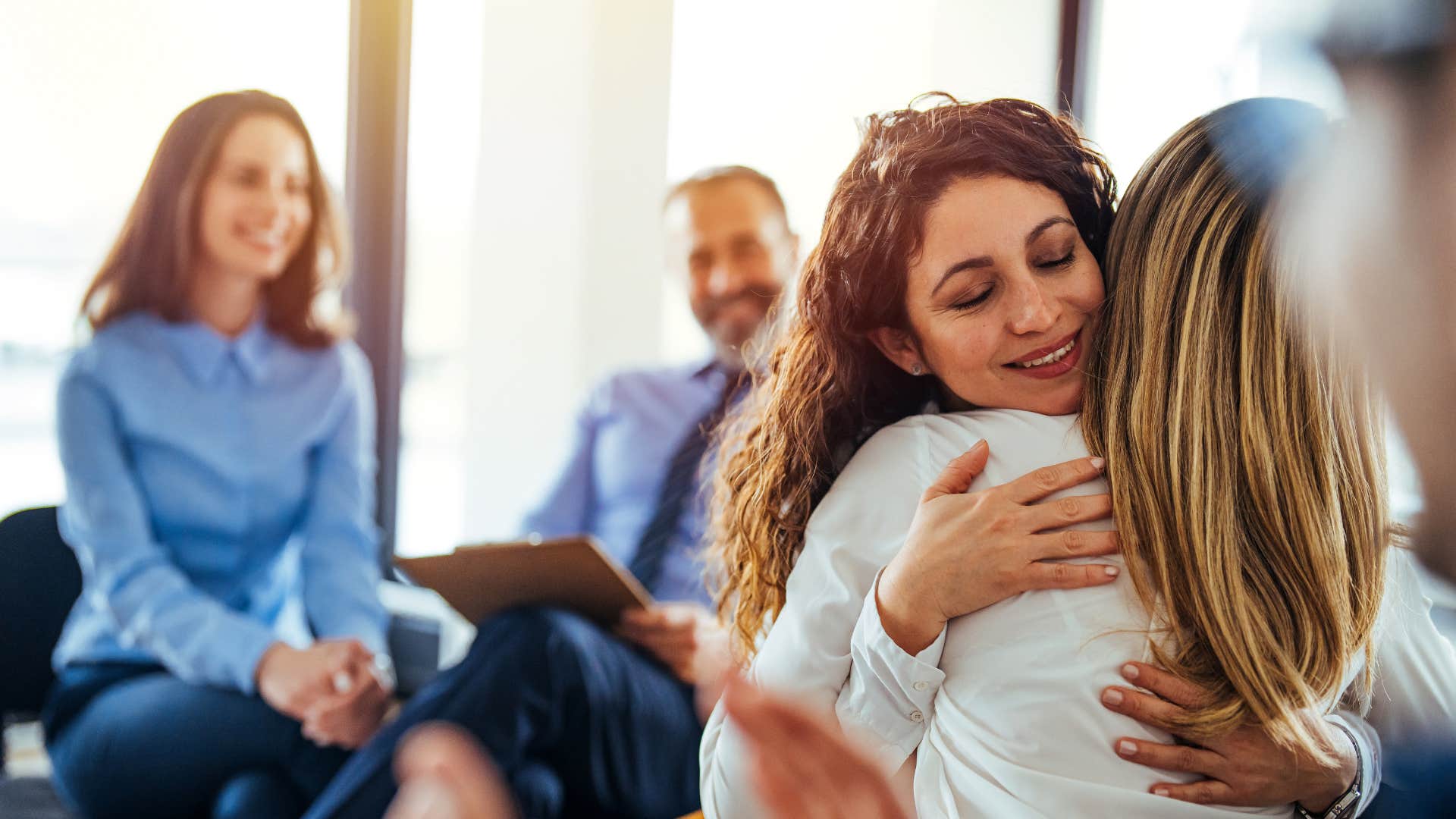 A woman hugs her friend who is going through a tough time and treats her how she would want to be treated.