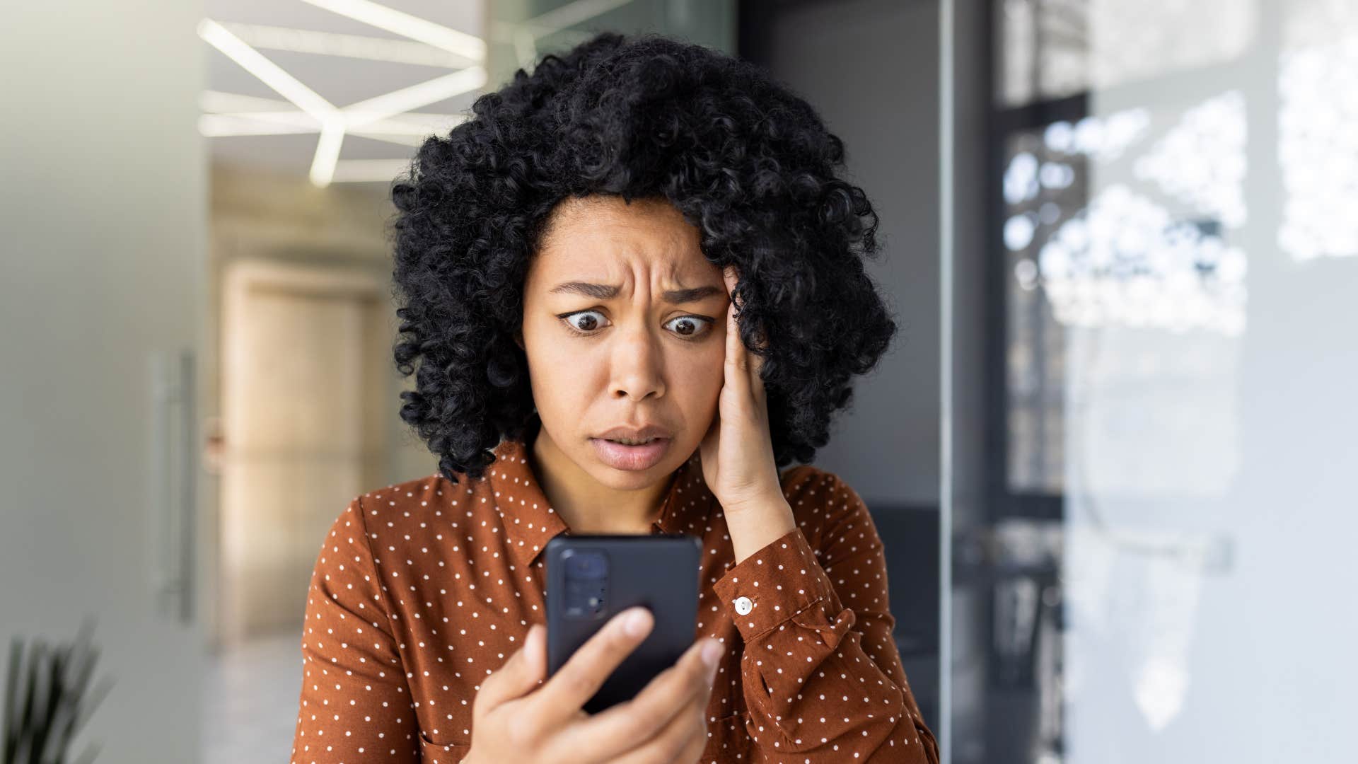 A woman reacts shocked at something that has happened.