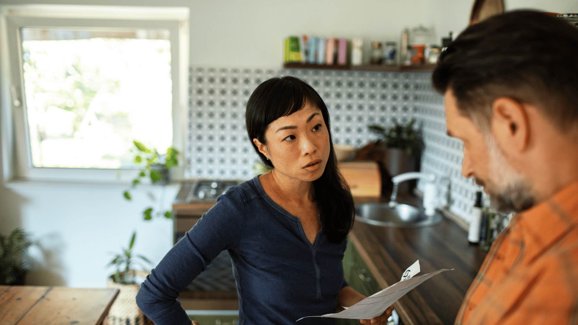 woman having serious conversation with man in kitchen