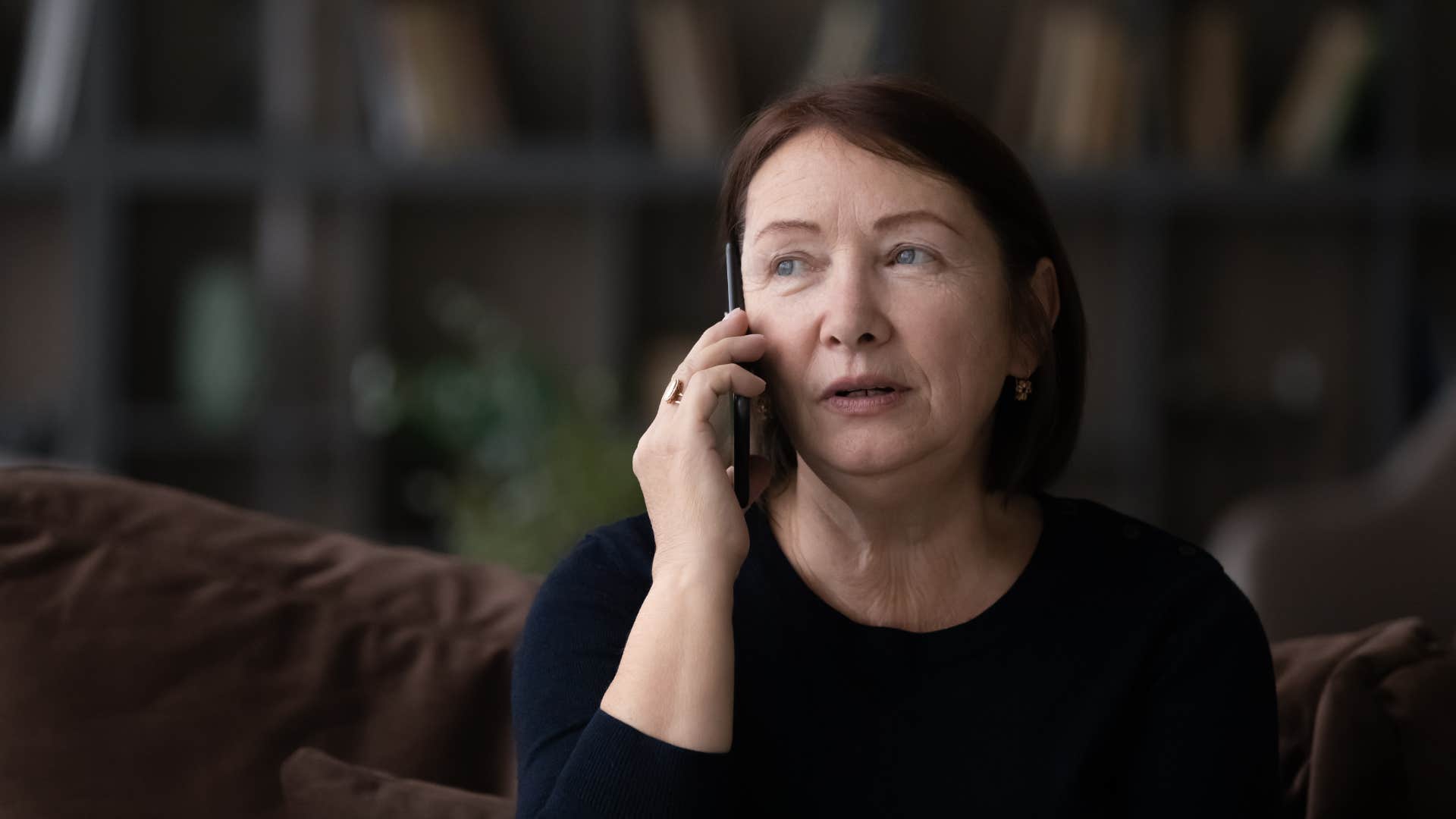 woman in black shirt on the phone sitting down and asking is there anything i should know about beforehand