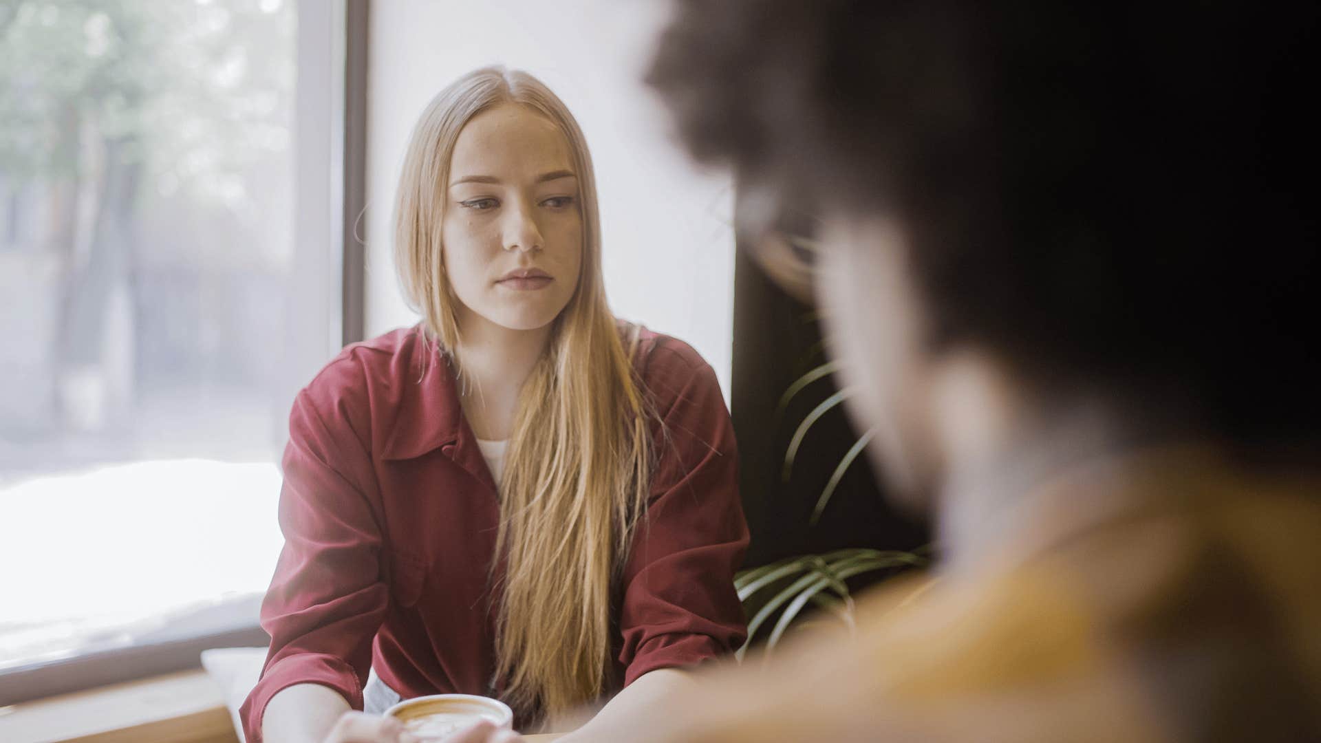 woman in red accepting things as she sits across from her partner
