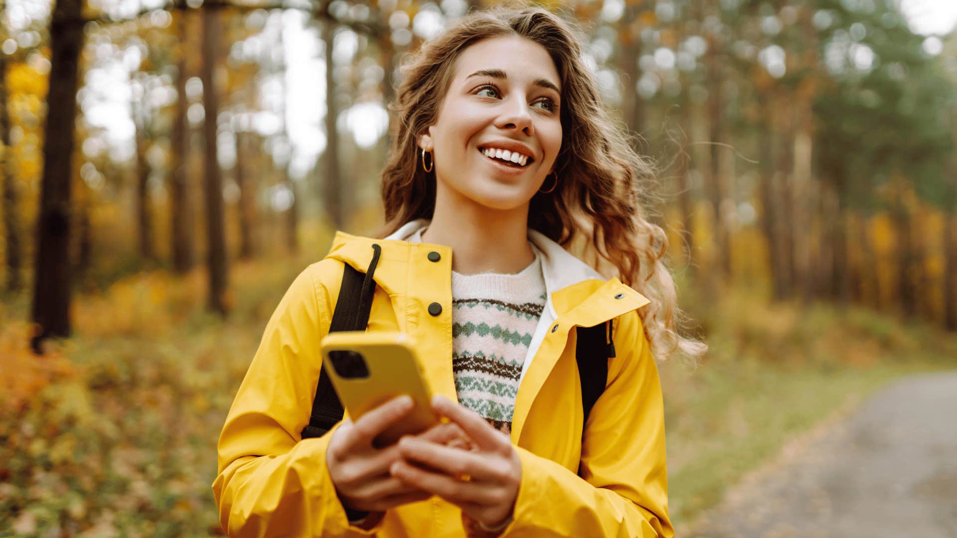 woman with yellow jacket on social media walking and smiling