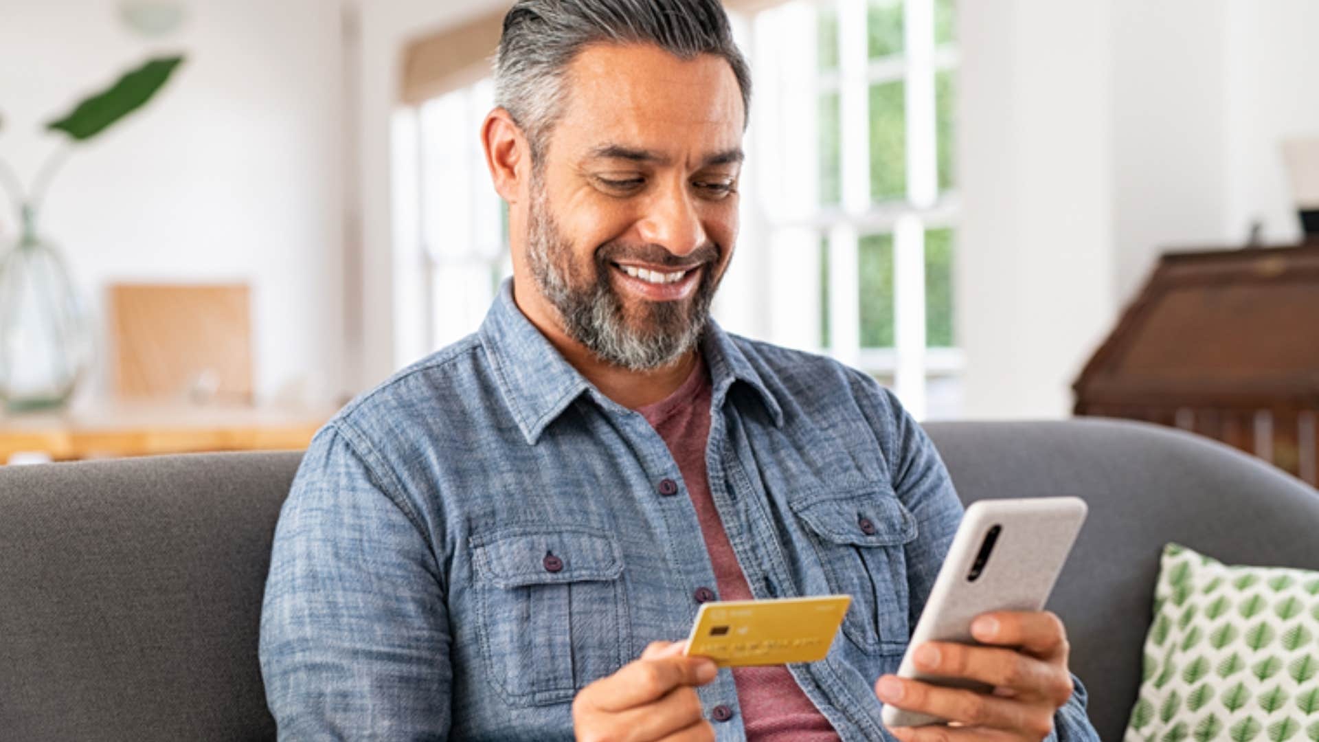 man making sure he pays his credit card bill to avoid late fees 