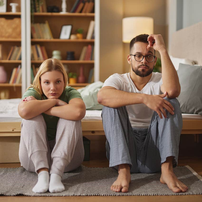 upset woman sitting next to man on floor