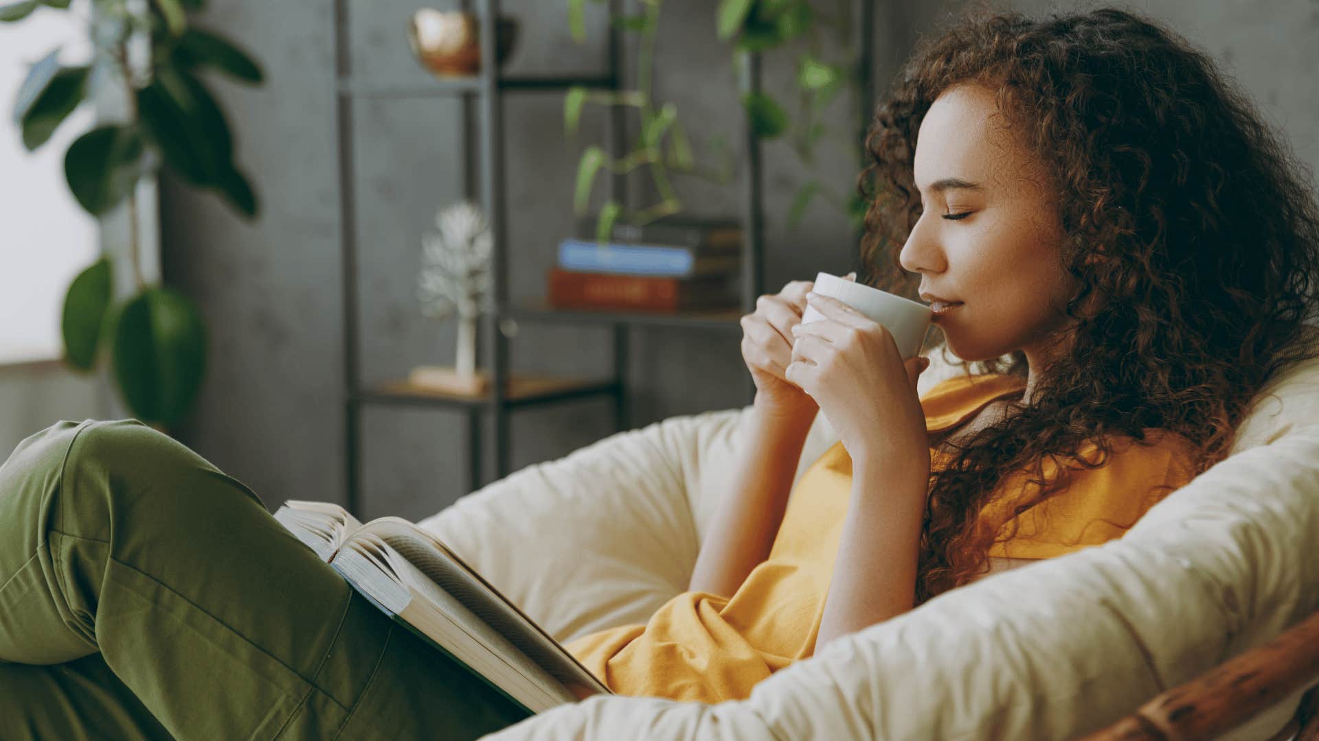 woman in yellow shirt living a drama free live and relaxing with a book and cup of tea