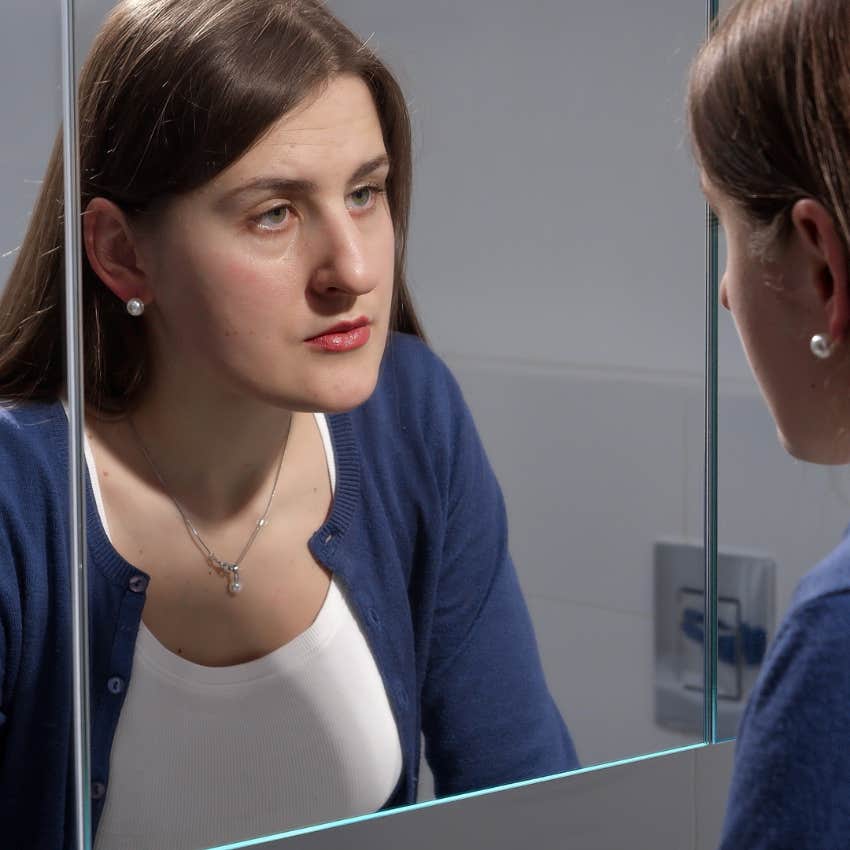 upset woman looking in mirror worried about emotional blindspots