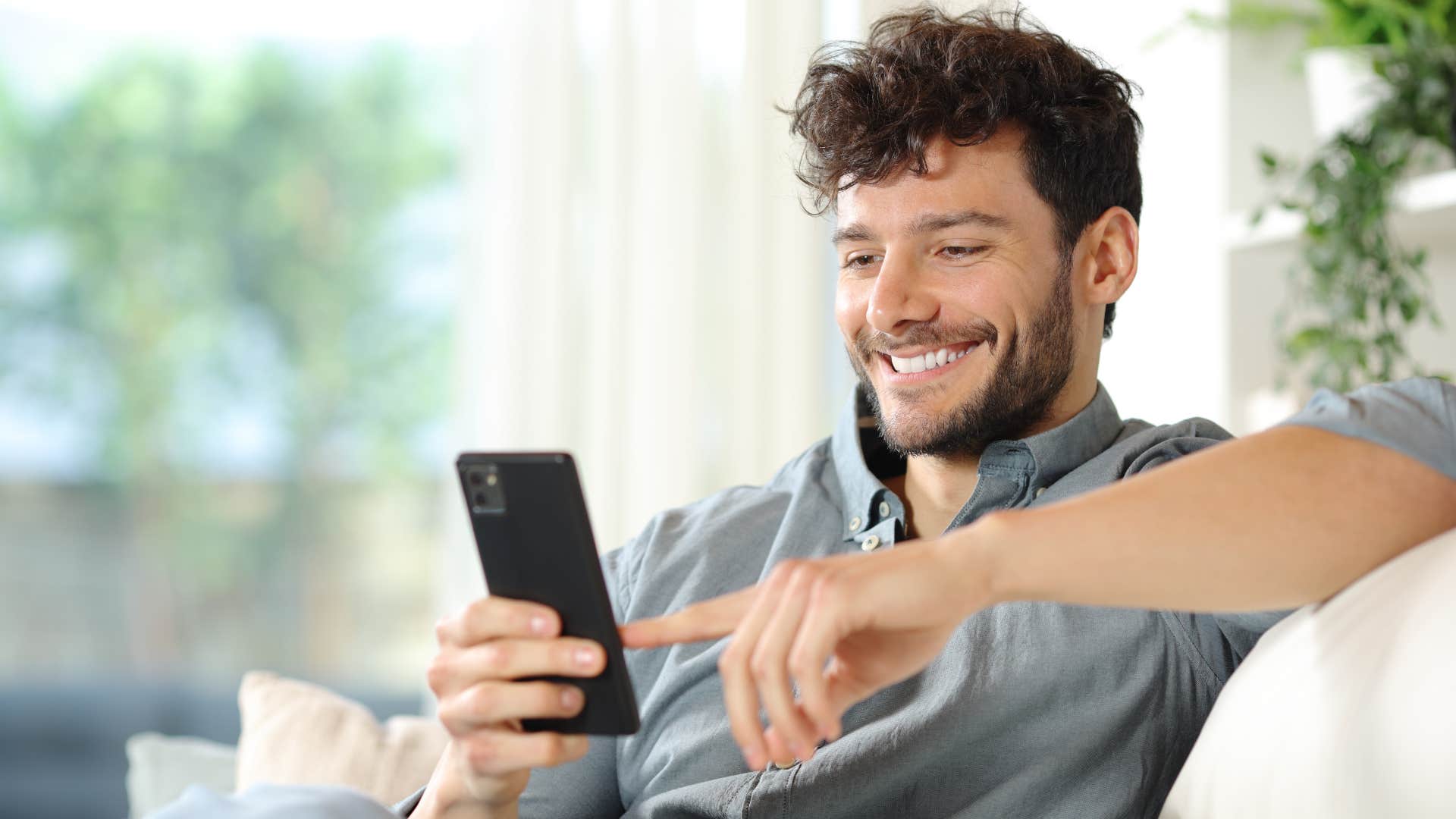 man perusing buy nothing Facebook groups on his phone