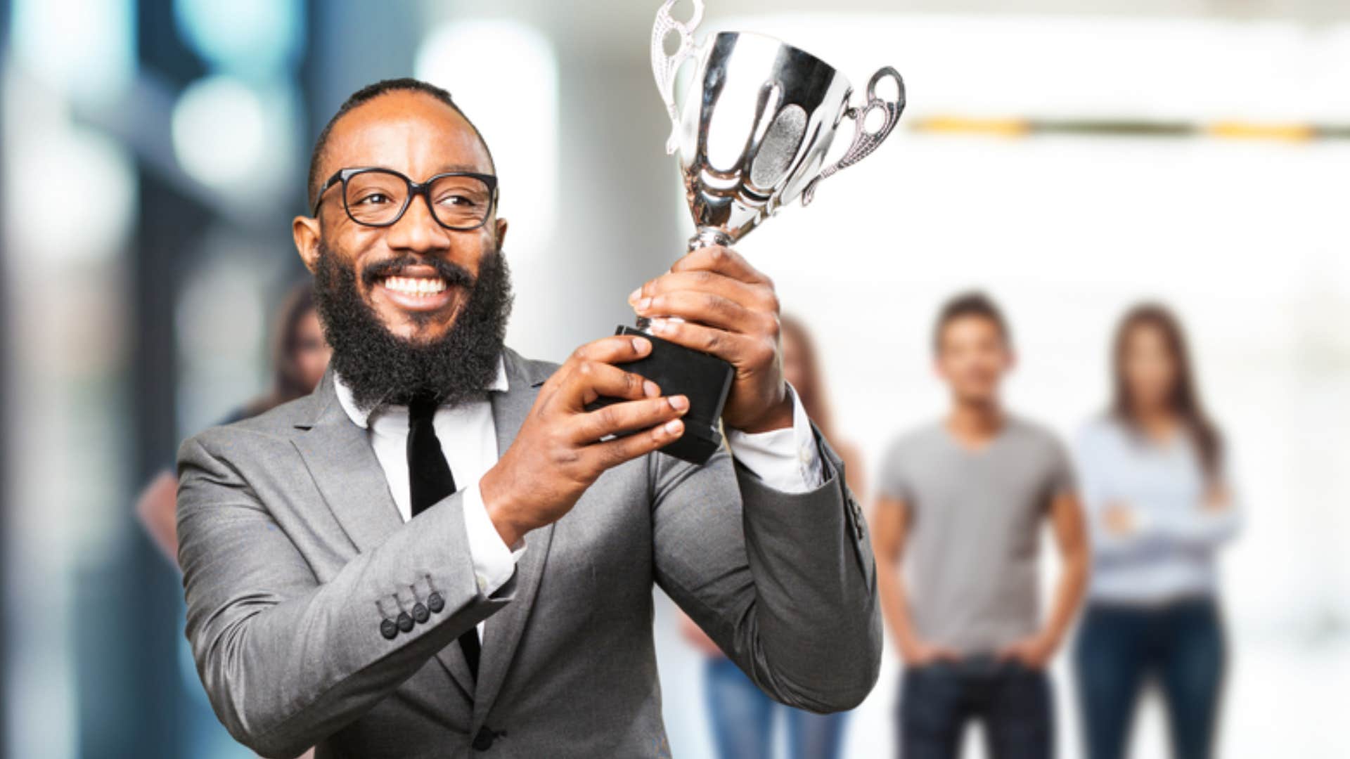 man holding trophy wanting to be rewarded